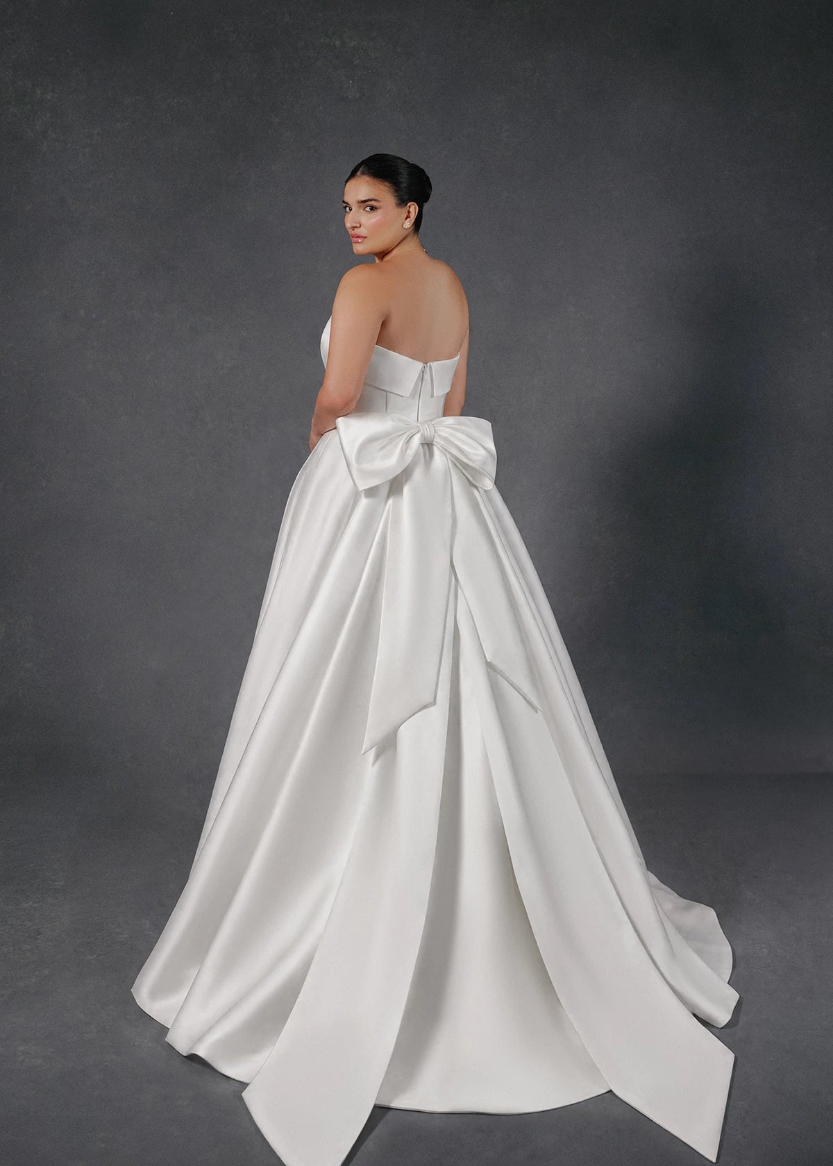 The Burke gown is a box pleated ballgown of Mikado Scuba with skirt slit and cuff neckline accented with Faille and Silk Organza floral appliqués in Silk White.