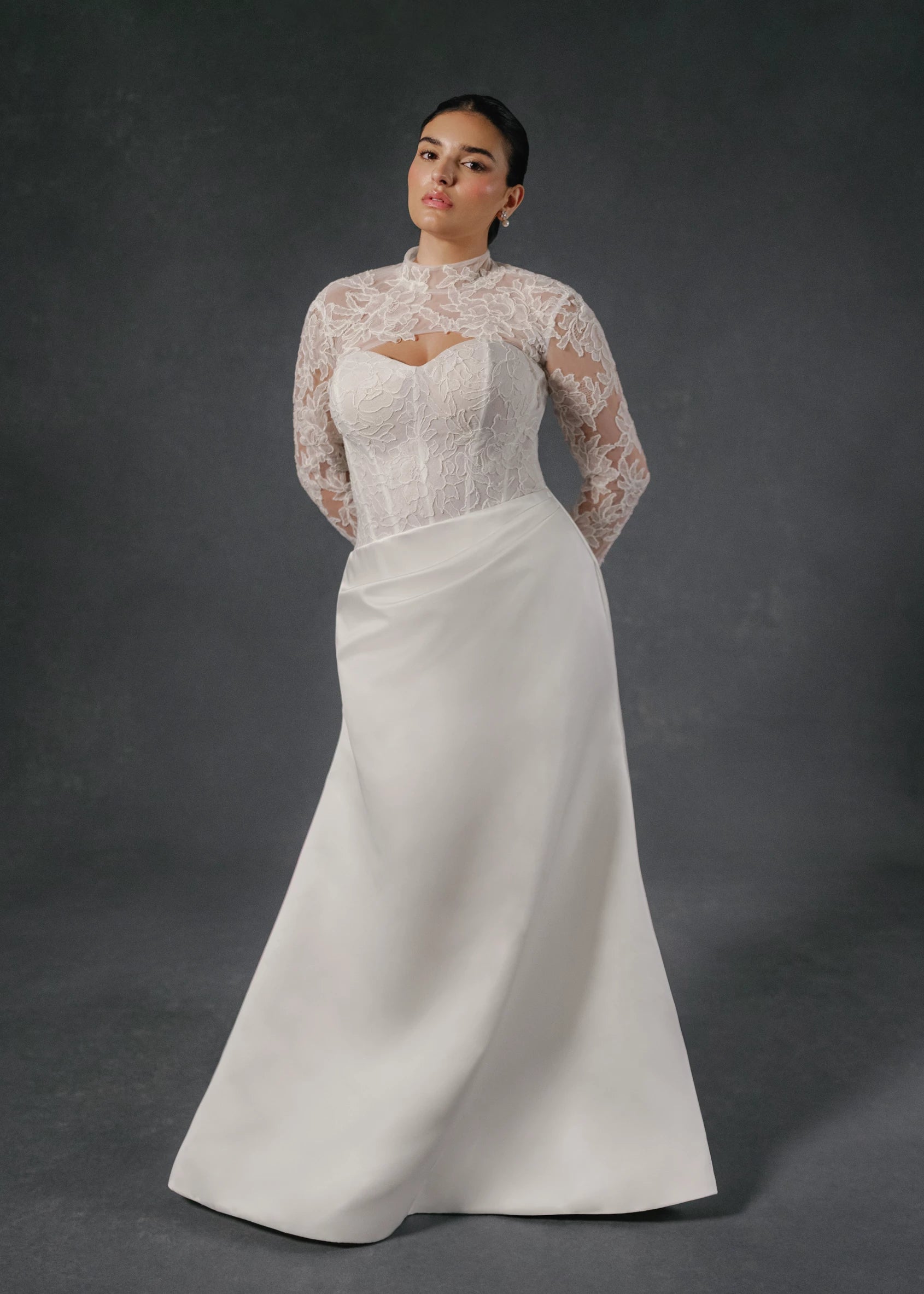 The Sully gown is an elongated corseted bodice accented with French Alenćon lace appliques, paired with trumpet skirt of Faille-Back Satin featuring soft draping at the waist in Silk White. 