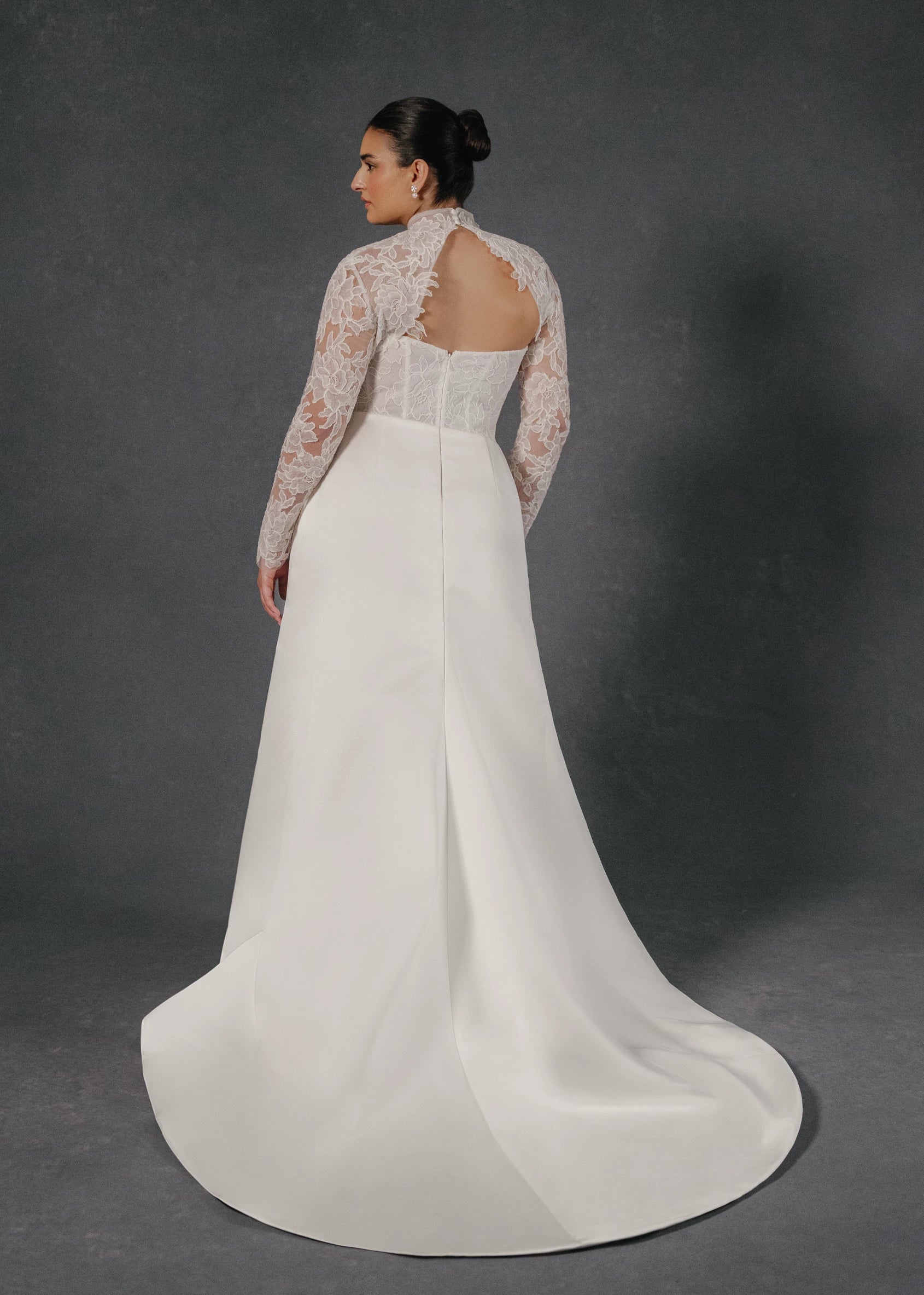 The Sully gown is an elongated corseted bodice accented with French Alenćon lace appliques, paired with trumpet skirt of Faille-Back Satin featuring soft draping at the waist in Silk White. 