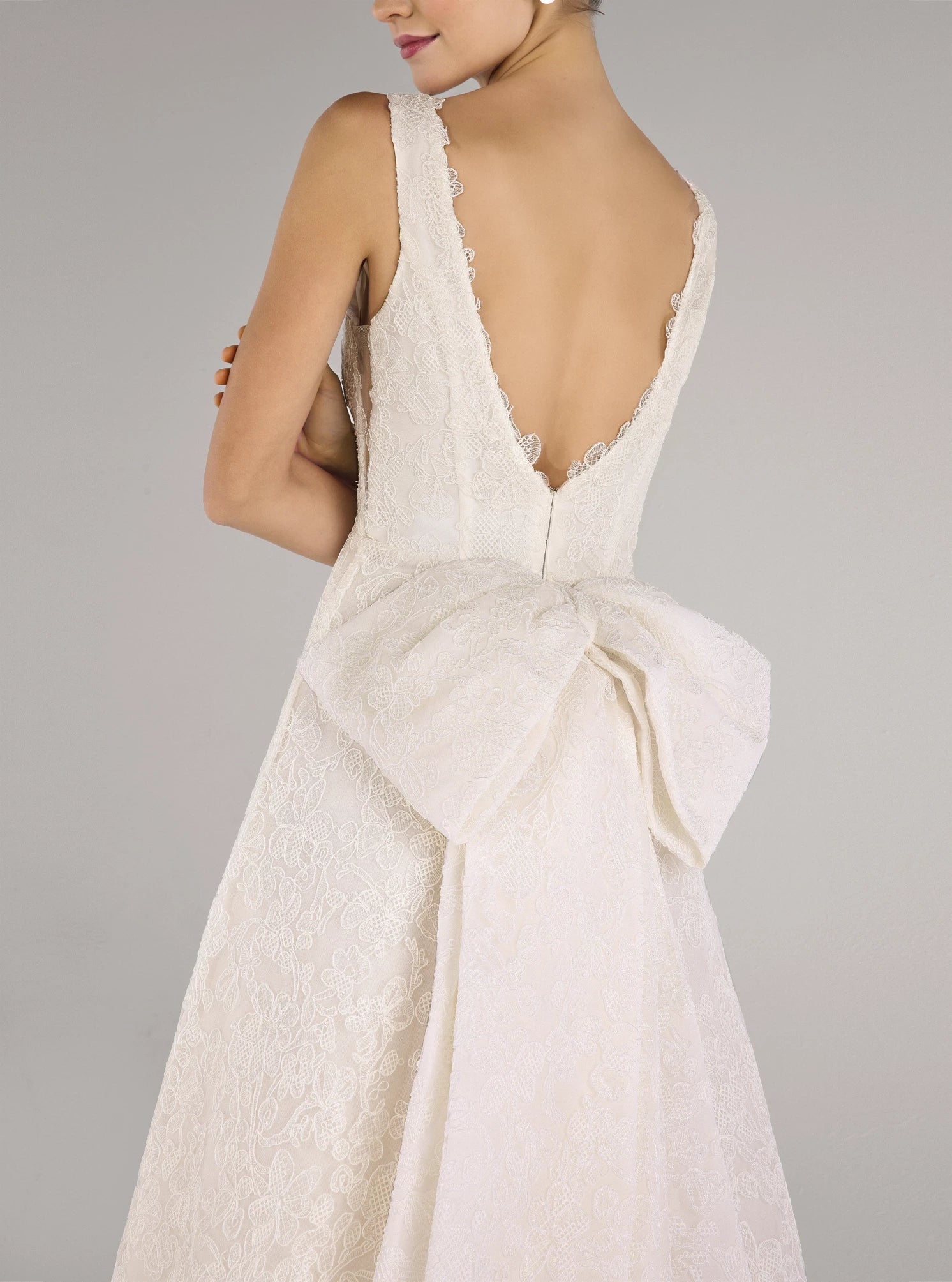 The Ashley gown is a V-neck gown of Scrollwork Embroidery with soft A-line skirt in Pearl.