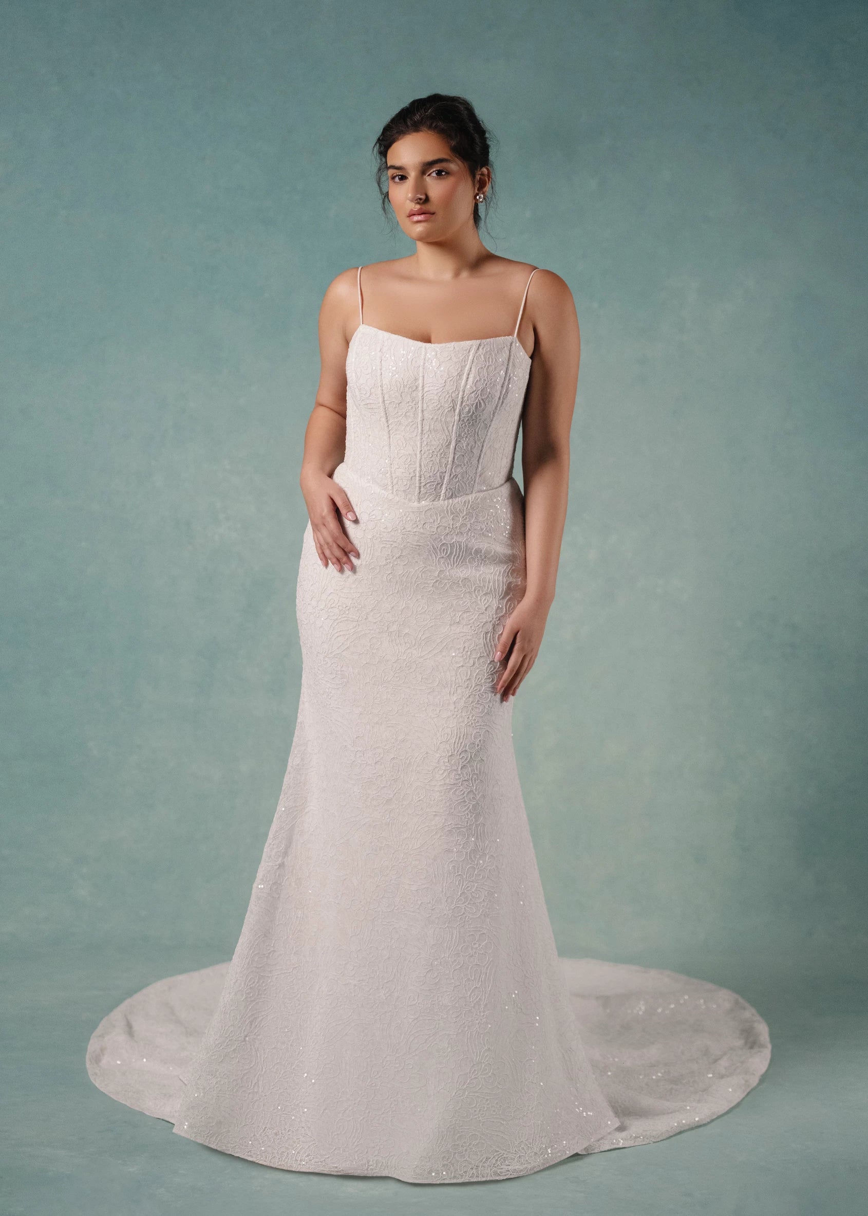 The Delia is a Spaghetti strap contour neckline gown with molded corset and softly flared skirt, in Sequined Corded Embroidery over Chantilly lace.