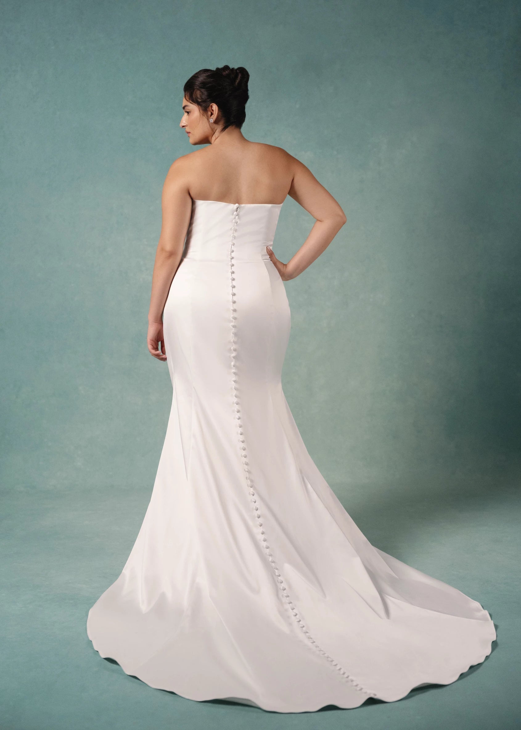 The Marielle gown is a dramatically draped column gown of Crepe-Back Satin featuring a peek-a-boo sweetheart neckline with Petal Beaded Embroidery and buttons to the hem