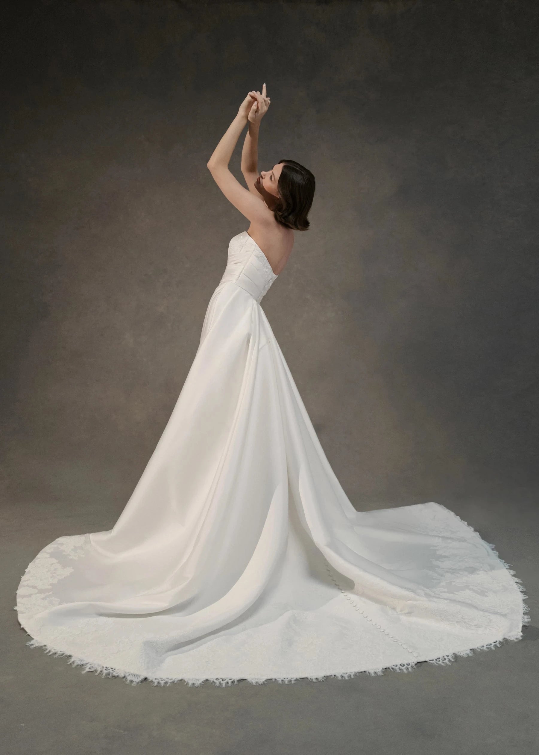 The Blue Willow Kaia Train is a dramatic detachable train of Soft Mikado, accented with a Corded Lace scalloped hem and buttons in Pearl.