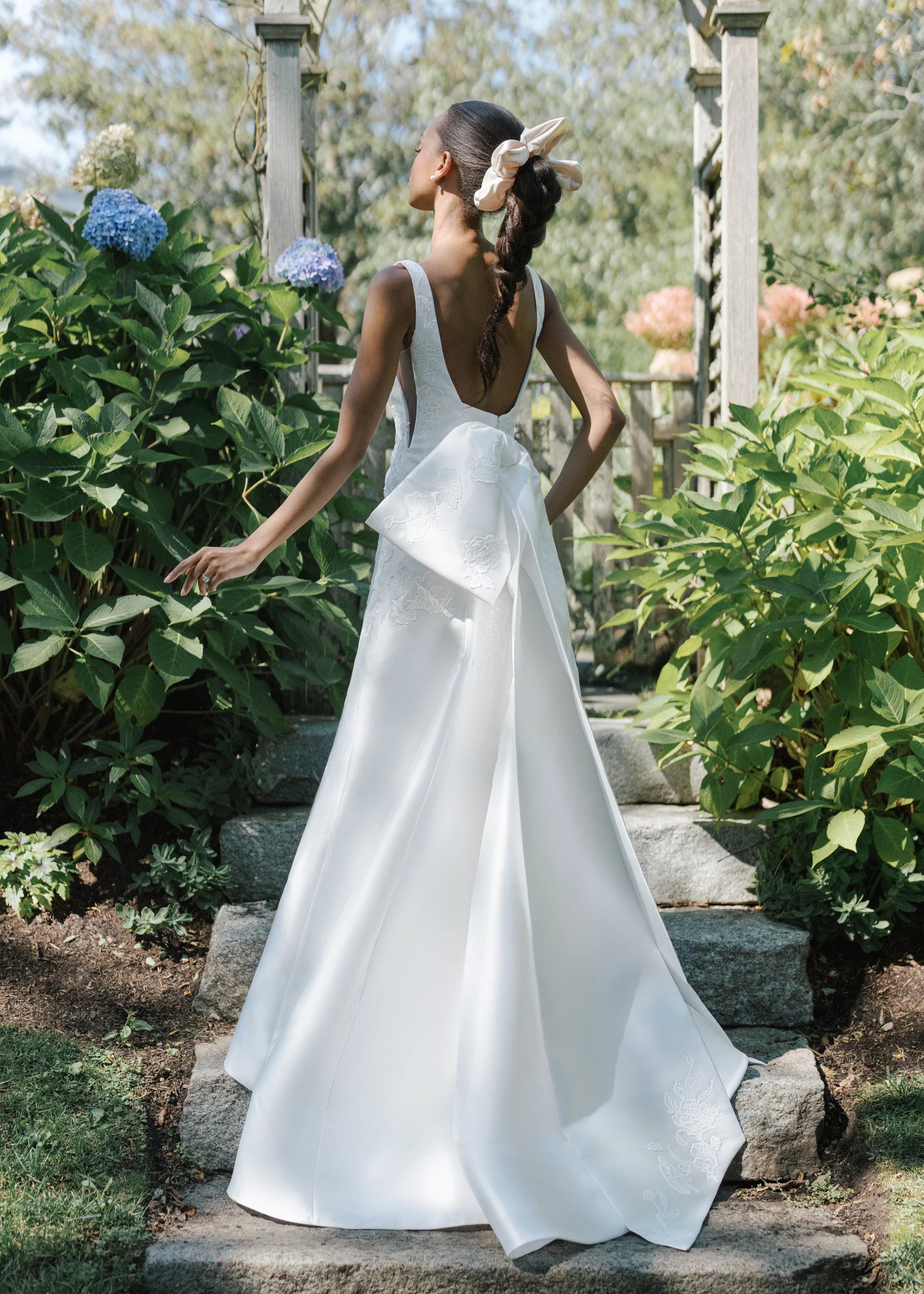The Blue Willow Sayle Bow is an asymmetric bow of Mikado dotted with Floral Vine Embroidery appliqués in Silk White.