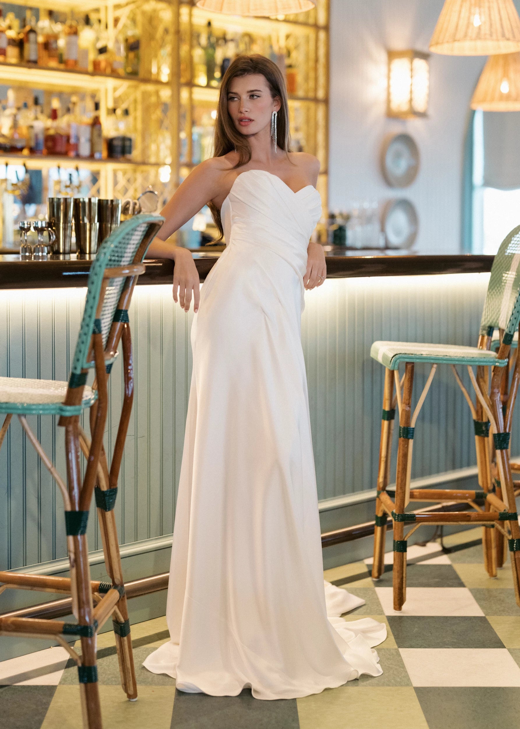 The Carlson gown is a sweetheart column gown of Double Faced Charmeuse with bodice draping opening to a draped cascading skirt in Silk White.