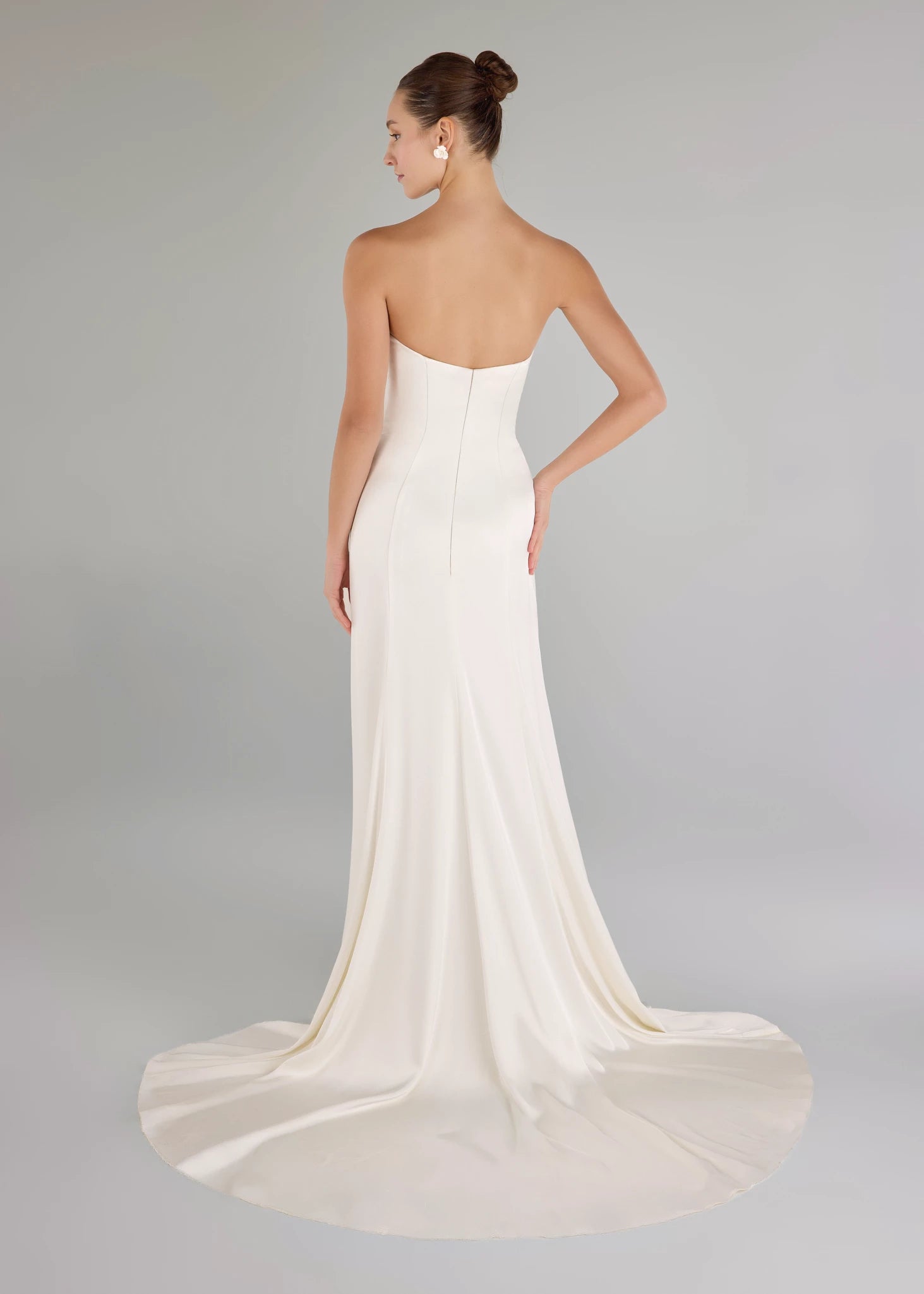 The Carlson gown is a sweetheart column gown of Double Faced Charmeuse with bodice draping opening to a draped cascading skirt in Silk White.