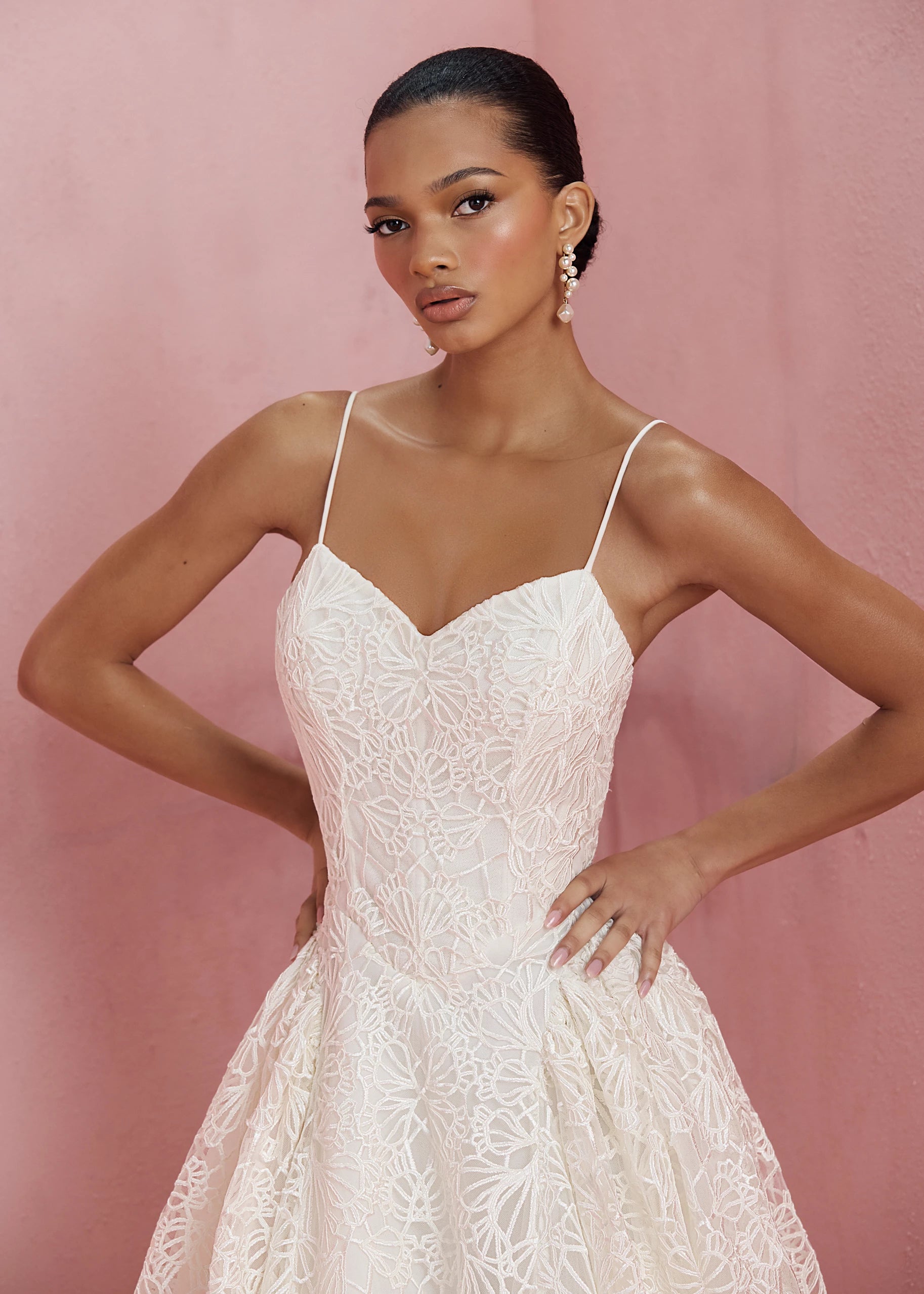 The Cecily gown is a spaghetti strap gown of Corded Satin Stitch Embroidery with basque waist, and architectural hip flares, flowing into a full A-line skirt in Pearl.
