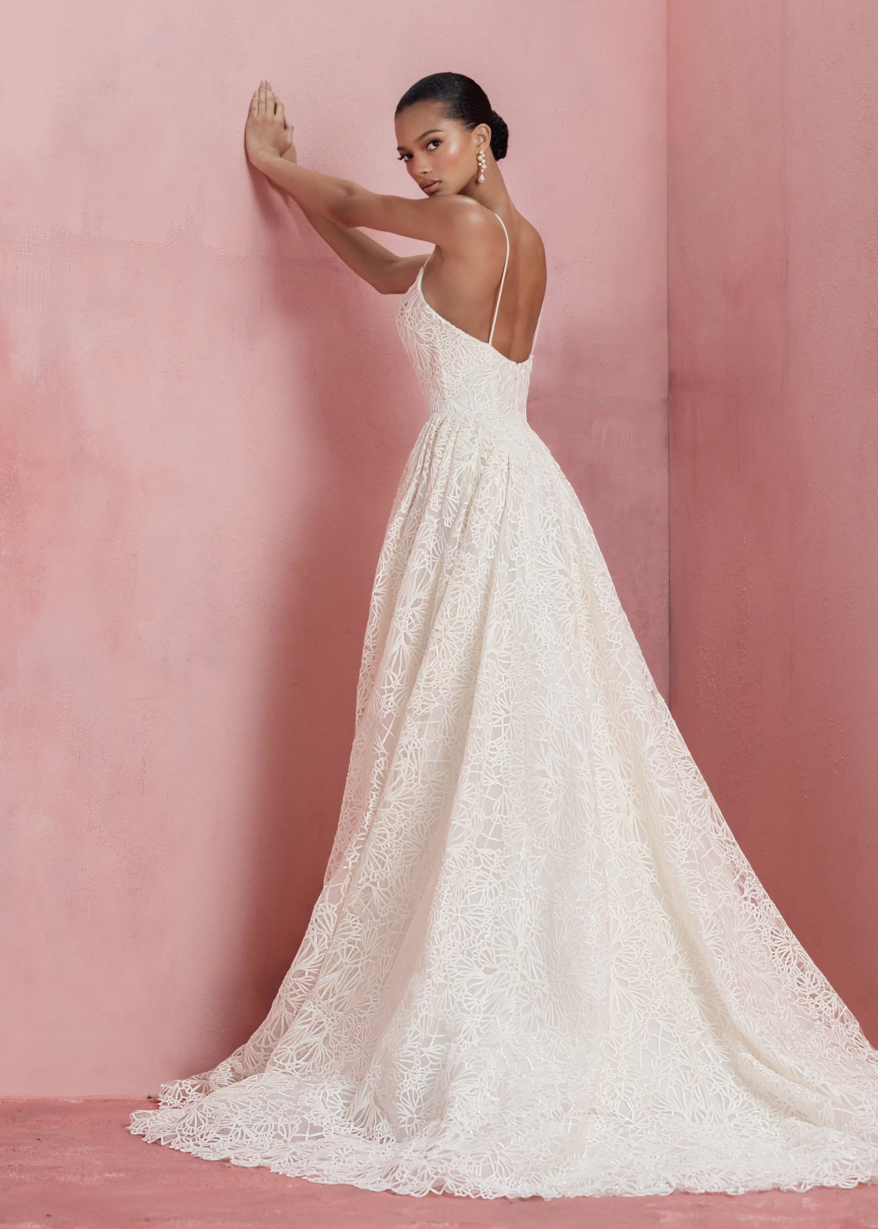 Back view of the Cecily gown, a spaghetti strap gown of Corded Satin Stitch Embroidery with basque waist, and architectural hip flares, flowing into a full A-line skirt in Pearl.