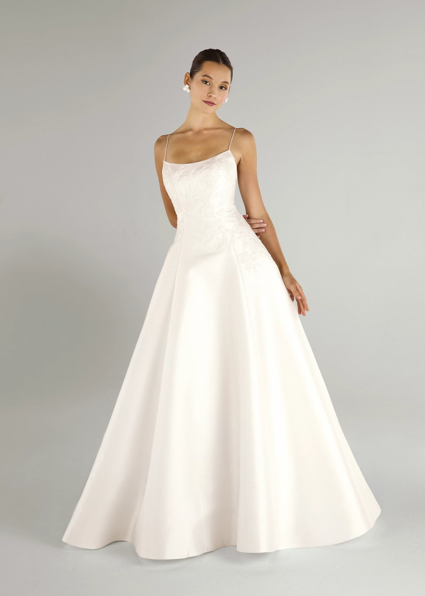 The Charlie gown is a scoopneck spaghetti strap A-line gown of Soft Mikado with Sequined Corded Floral Lattice appliqués in Pearl.
