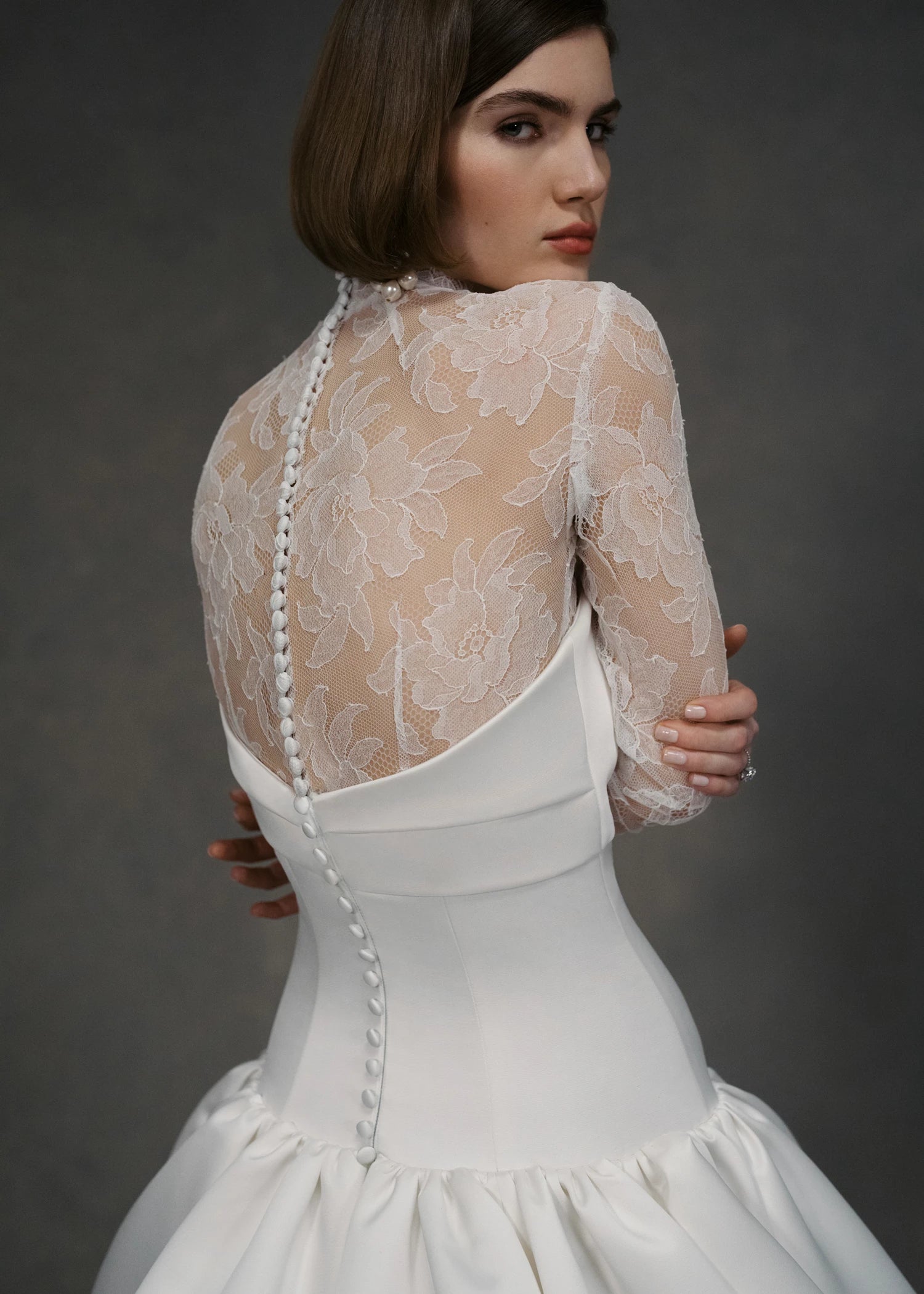 The Cyrus Topper by Anne Barge, a long sleeve mockneck top of Chantilly lace with lace-covered buttons and loops at back and wrists in Silk White.