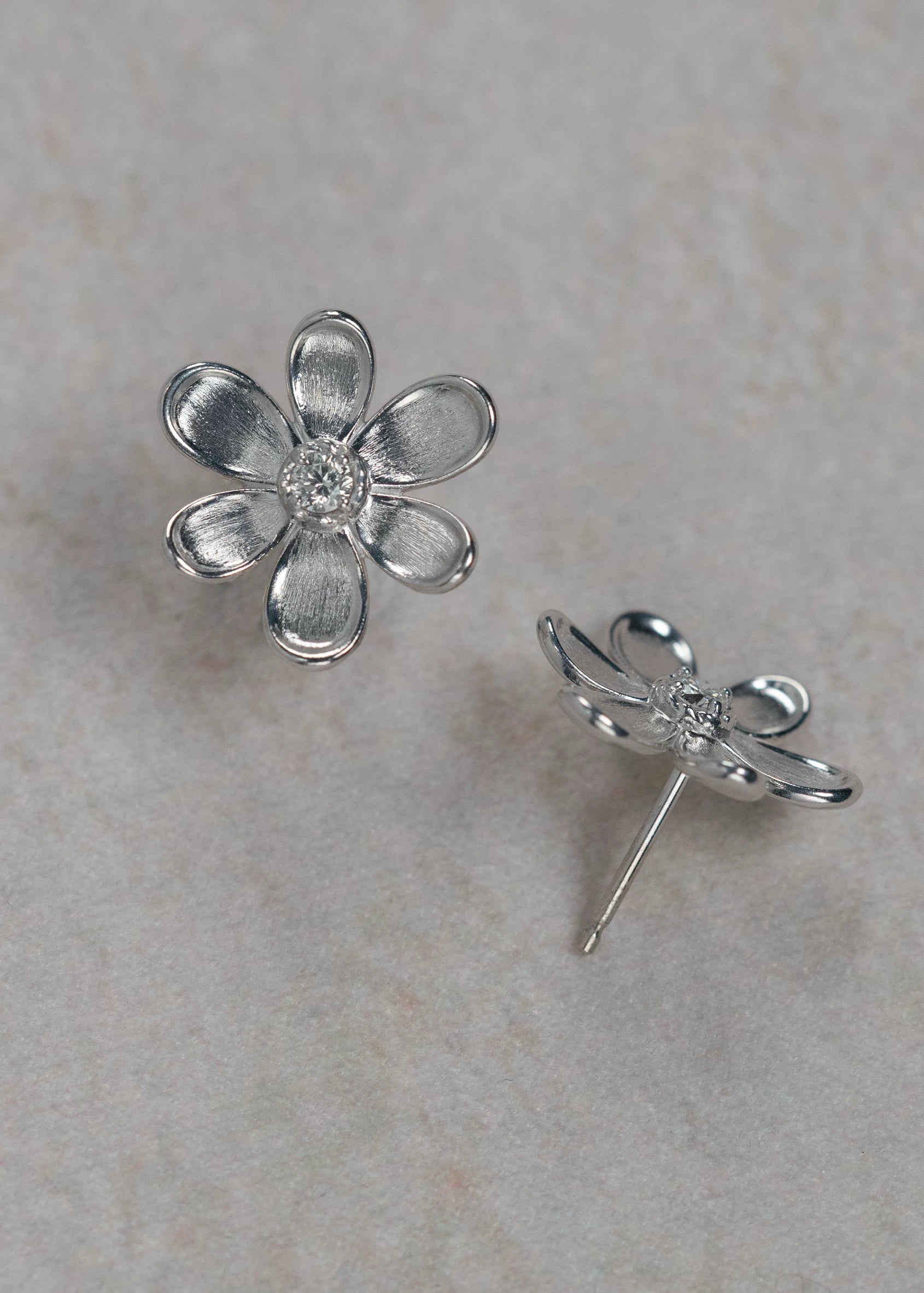 Designed by Atlanta jewelry designer Laura Pearce, delicate Daisy flower studs, featuring a 0.20 CTTW brilliant diamond, and available in 8K Yellow or White Gold.