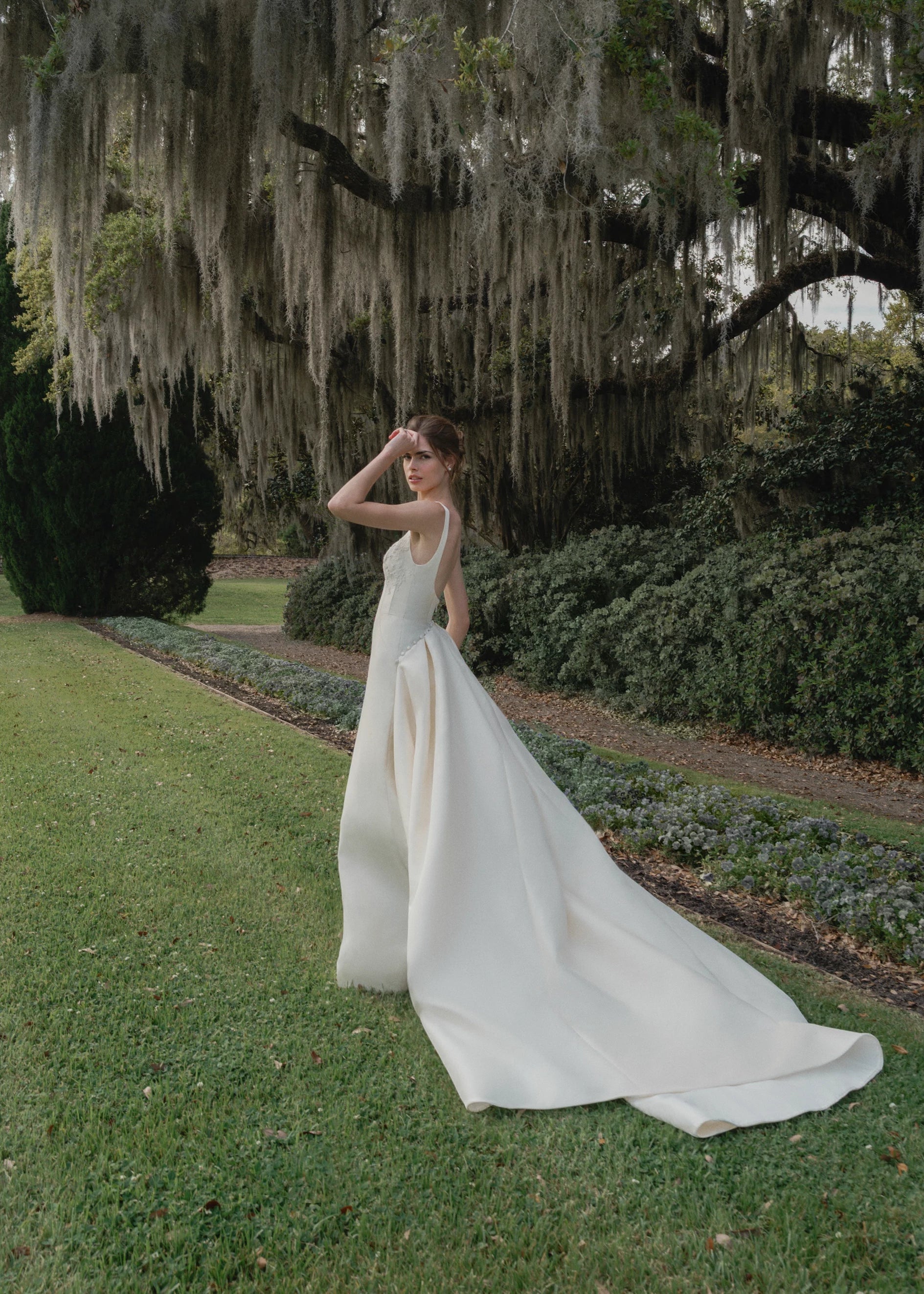 The Henrietta gown is a soft scoop neck trumpet gown of Italian Kalika with architectural seaming, featuring French Alençon lace framing the neckline.