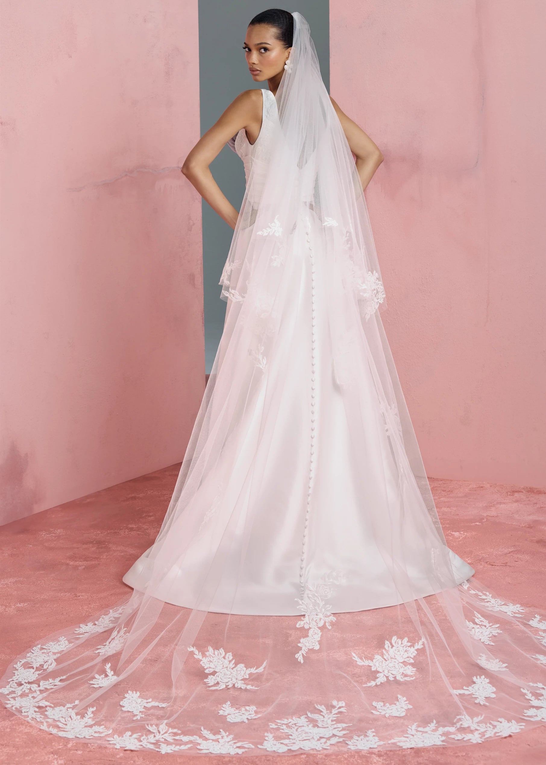 The Joelle gown is a soft Mikado modified A-line gown with plunging V-neckline accented with Thread-Sketched Floral Embroidered Appliques, pleated cummerbund waist, and buttons to the hem in Pearl.