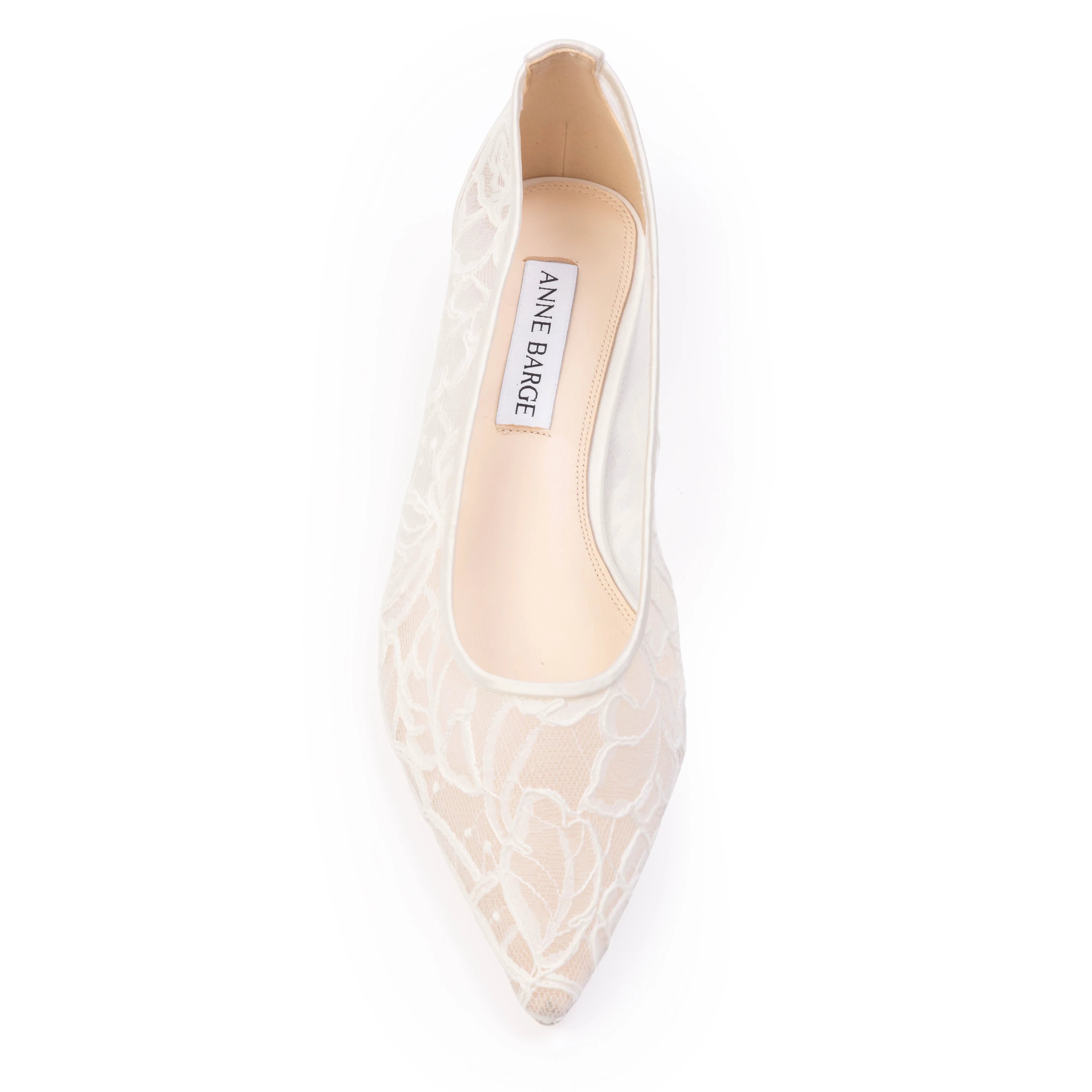 Anne Barge bridal ballerina featuring a pointed toe and minimalist micro-heel, designed with a graceful scooped throatline. Crafted in smooth satin and accented with delicate lace and floral appliqué.