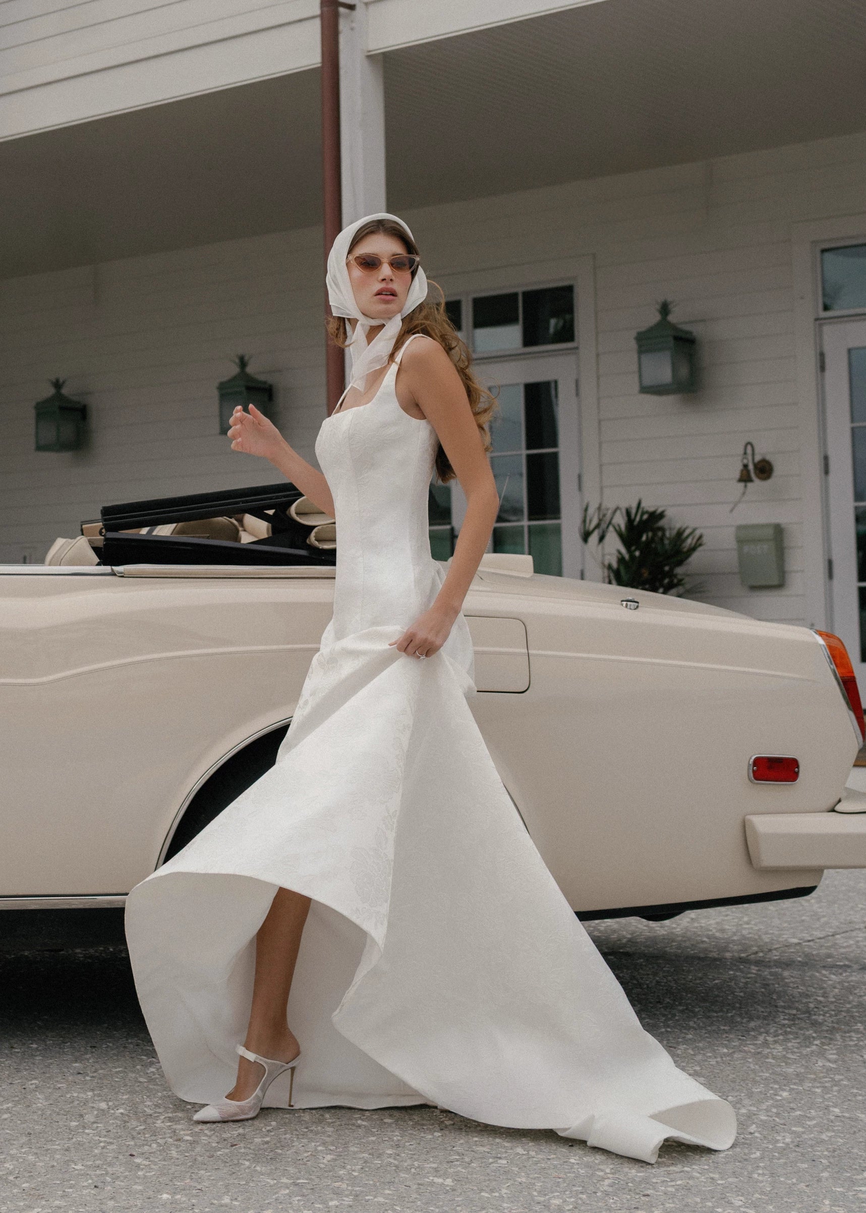 The Kiawah gown is a square neckline fit and flare gown of Embossed Jacquard with curved drop waist in Pearl.