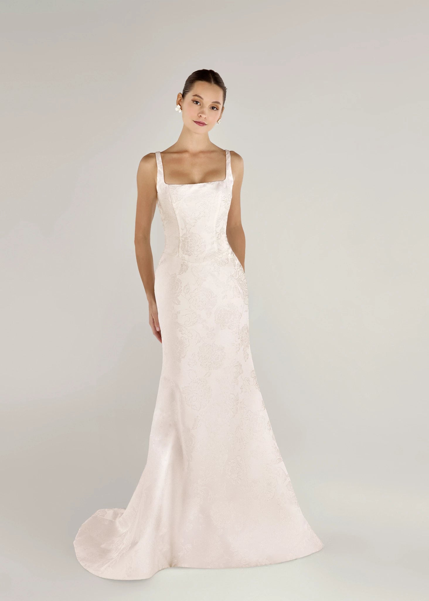 The Kiawah gown is a square neckline fit and flare gown of Embossed Jacquard with curved drop waist in Pearl. 