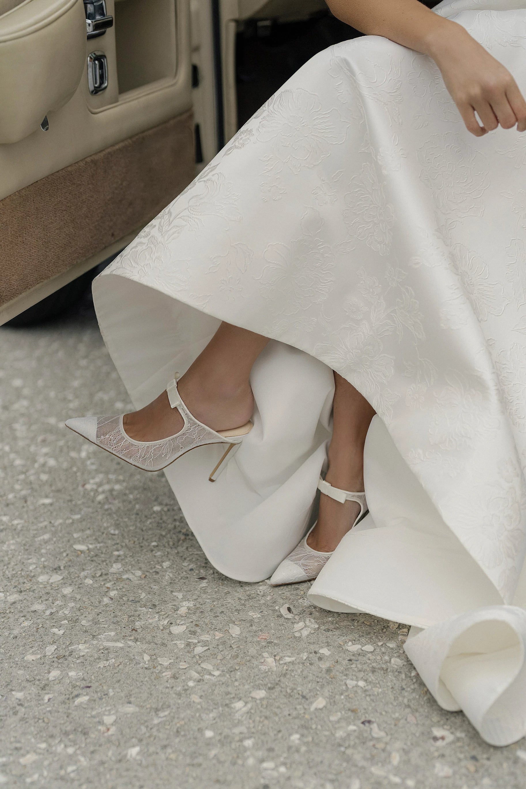 The Anne Barge Luna wedding shoe, is a pointy toe White Sequins Lace slip on pump with a 100 mm heel and a self covered bow, set on a stiletto pin heel.