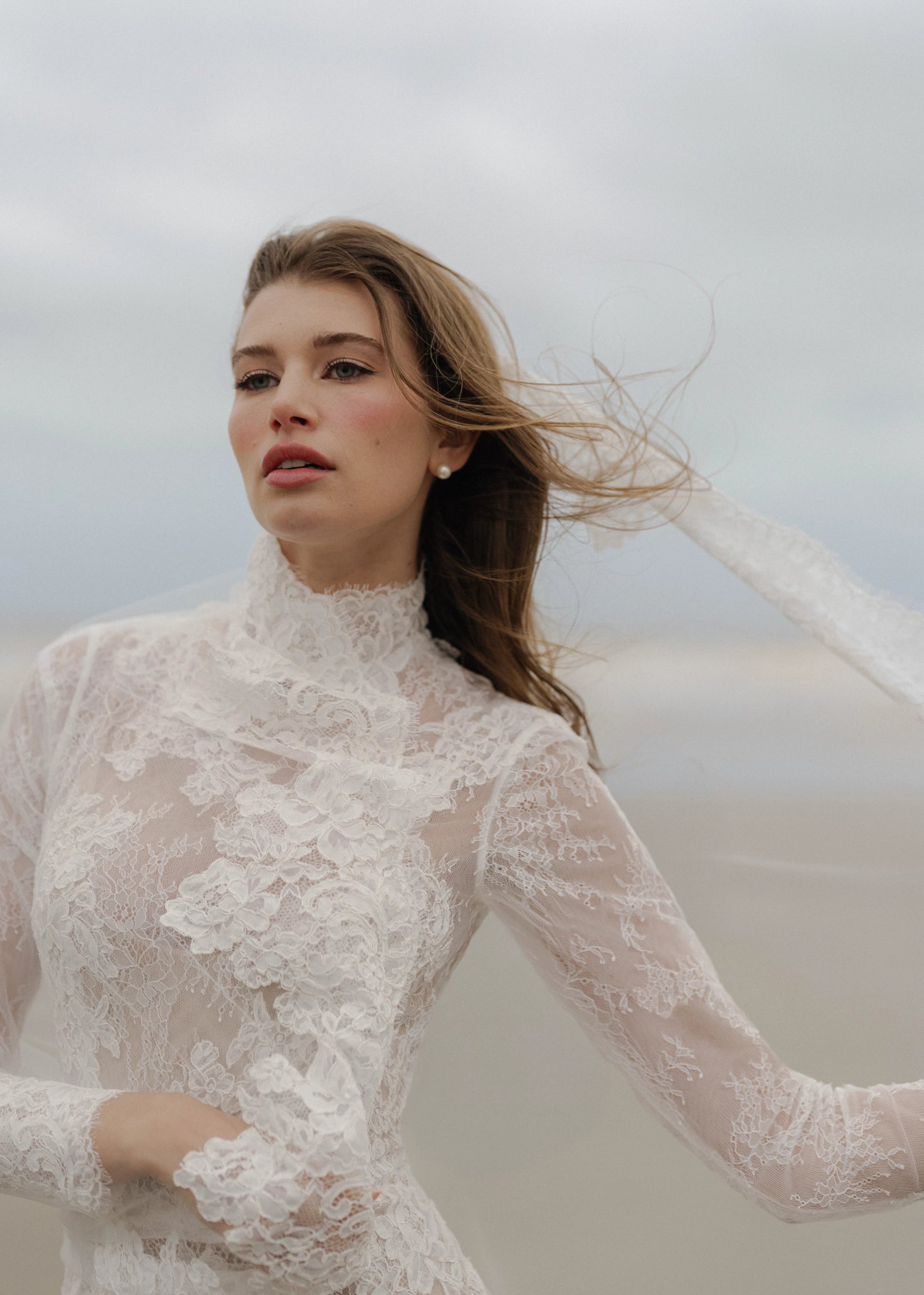 The Leo gown is a mockneck long sleeve columnar gown of Corded Lace gown with Chantilly lace underlay.