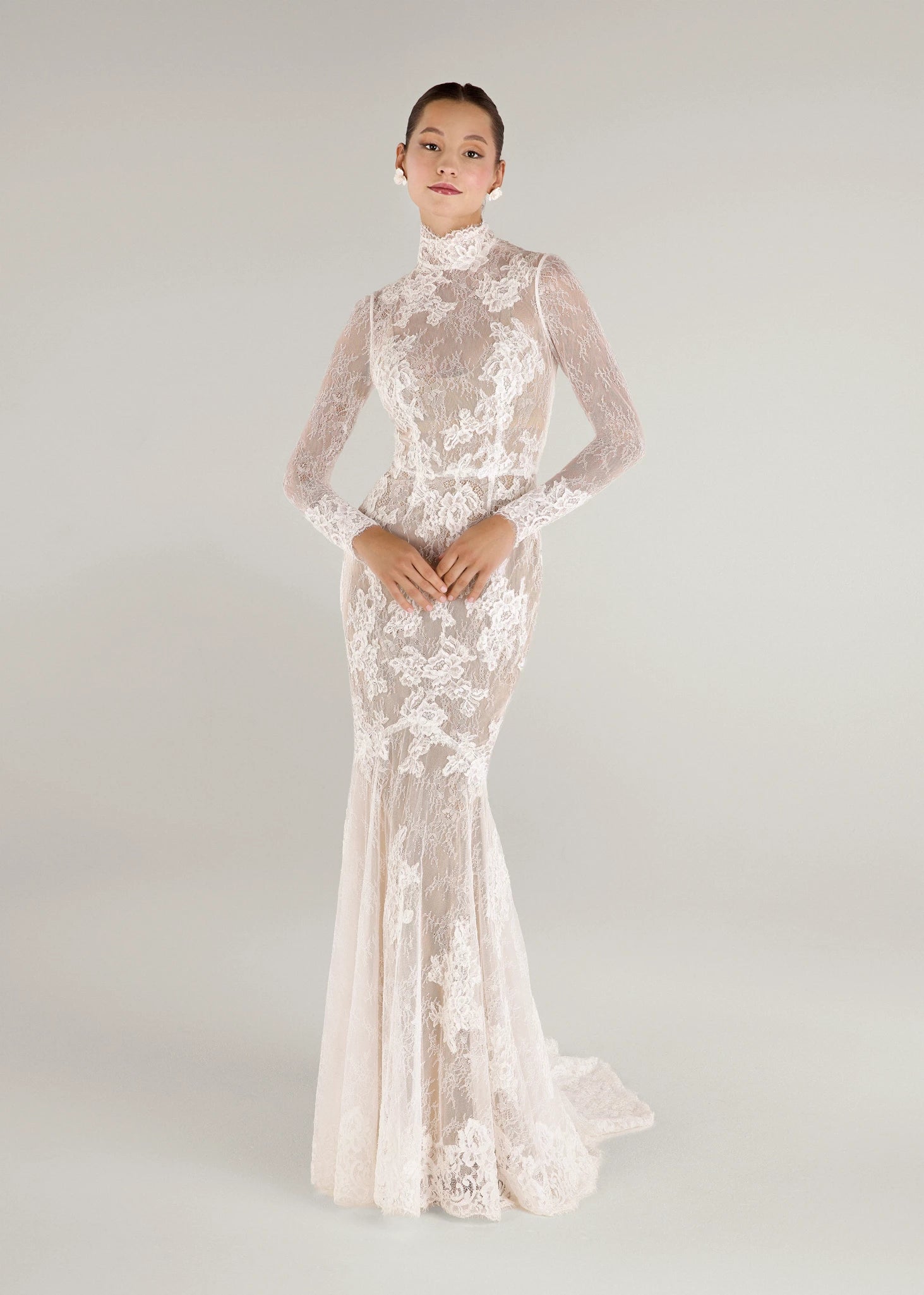 The Leo gown is a mockneck long sleeve columnar gown of Corded Lace gown with Chantilly lace underlay in Silk White. Shown with the Leo Slip; a powernet slip available as a separate piece