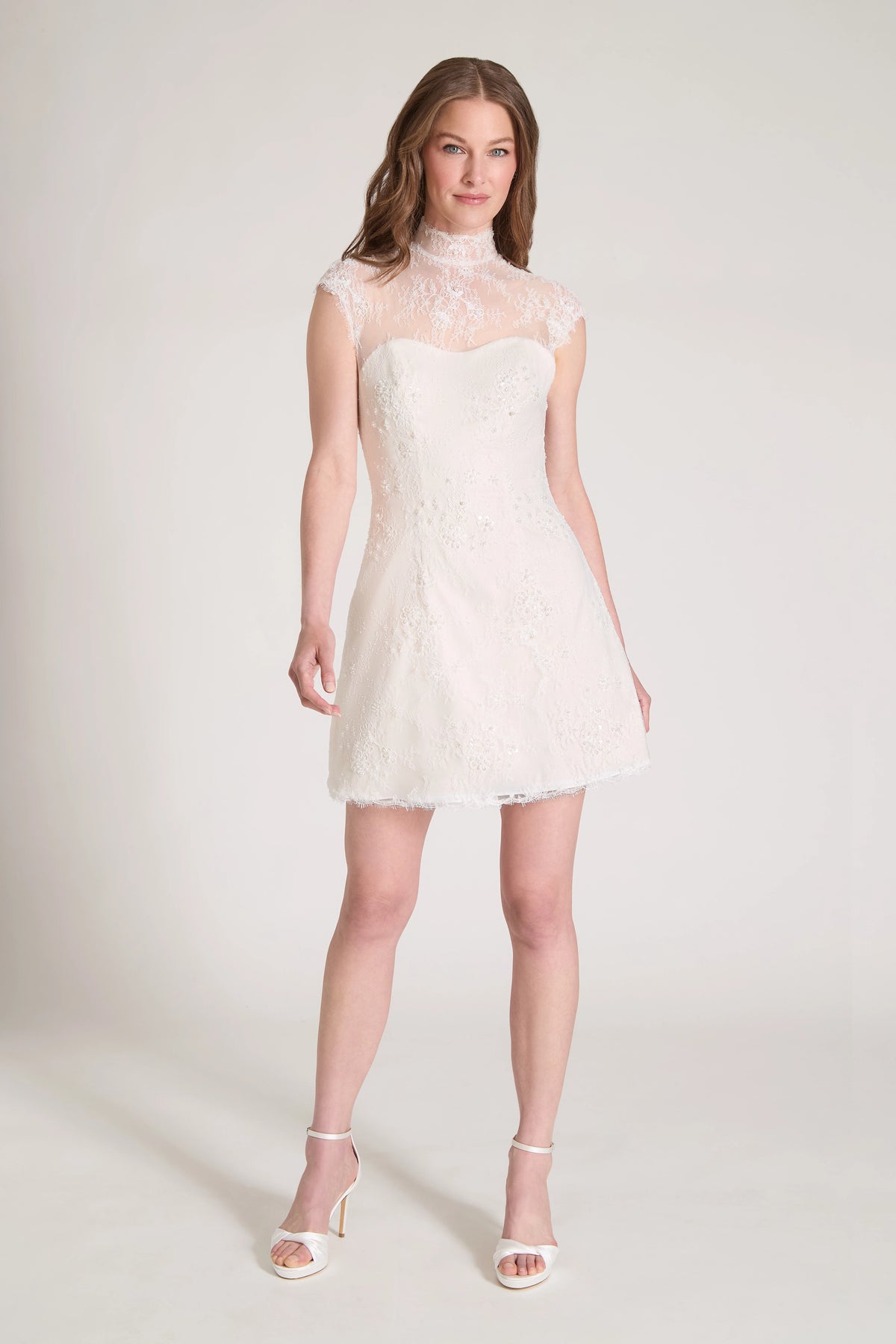 The Blush Crush Little White Dress is a mockneck cap sleeve mini dress of Corded Beaded Chantilly Lace with soft nude tulle underlay in Silk White/Nude.