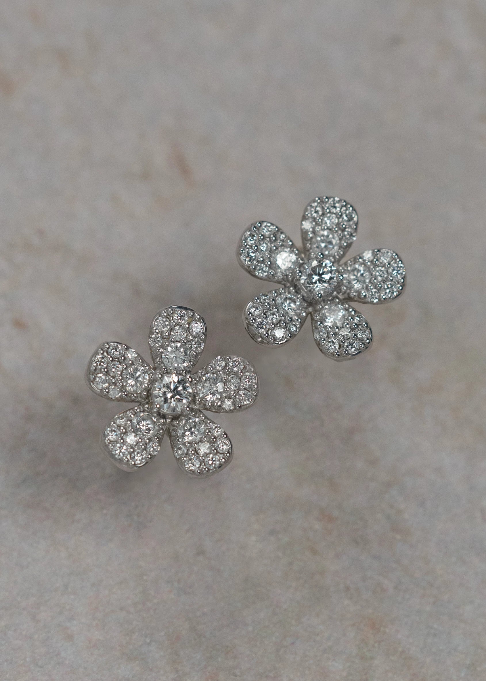Designed by Atlanta jewelry designer Laura Pearce, delicate pave diamond daisy studs, featuring 0.95 CTTW in brilliant diamonds, and available in 18K Yellow or White Gold.