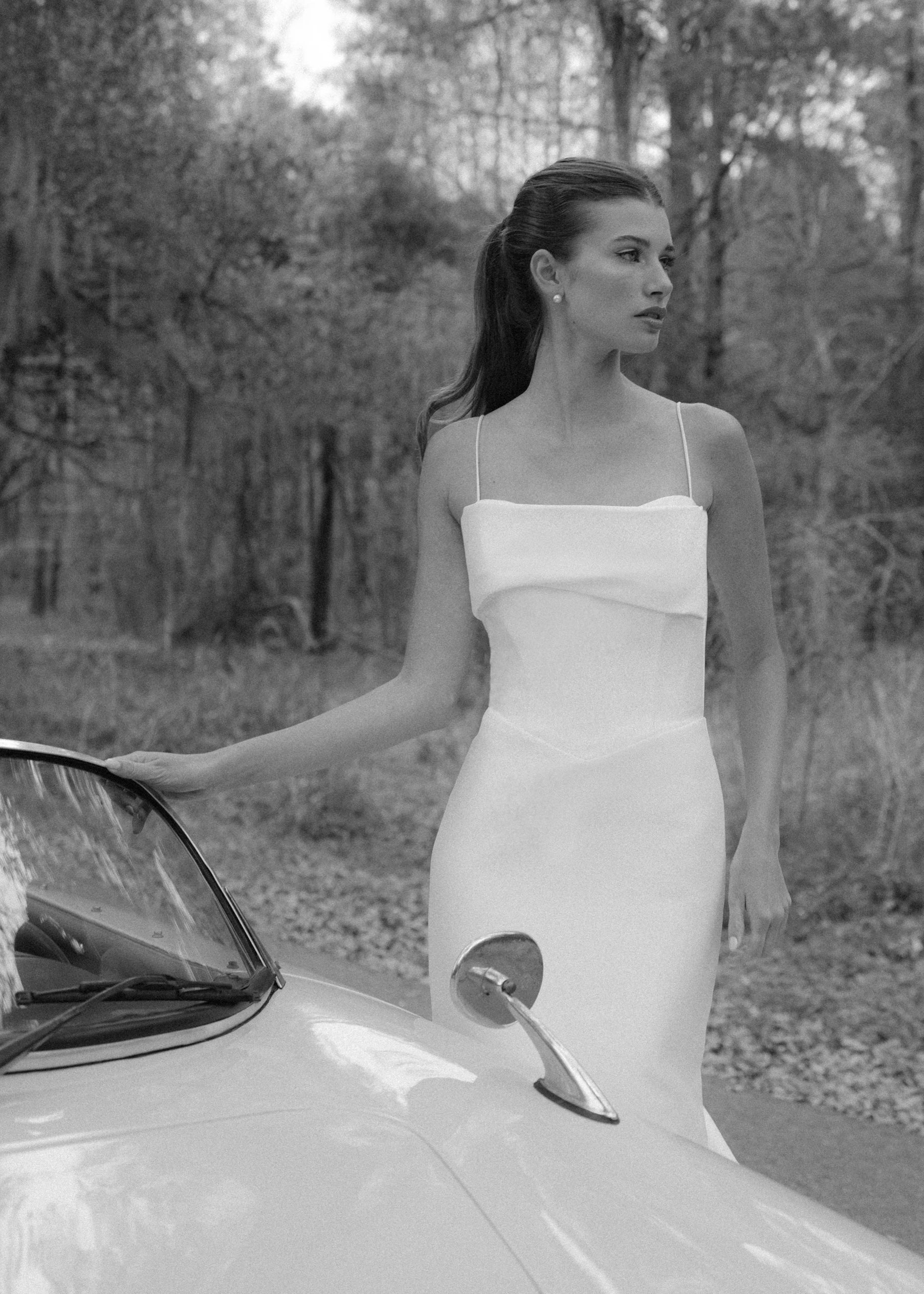 The Radcliffe gown is a spaghetti strap fit and flare gown of Soft Mikado with sculpted bodice, asymmetric bodice draping and buttons to the hem.