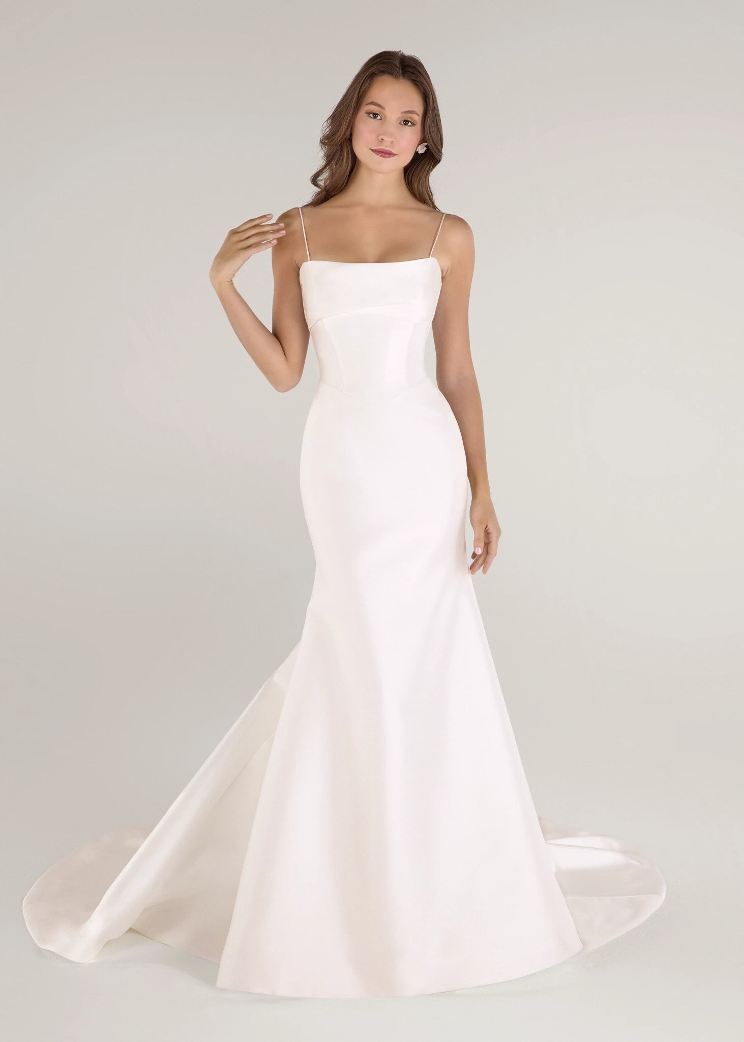 The Radcliffe gown is a spaghetti strap fit and flare gown of Soft Mikado with sculpted bodice, asymmetric bodice draping and buttons to the hem