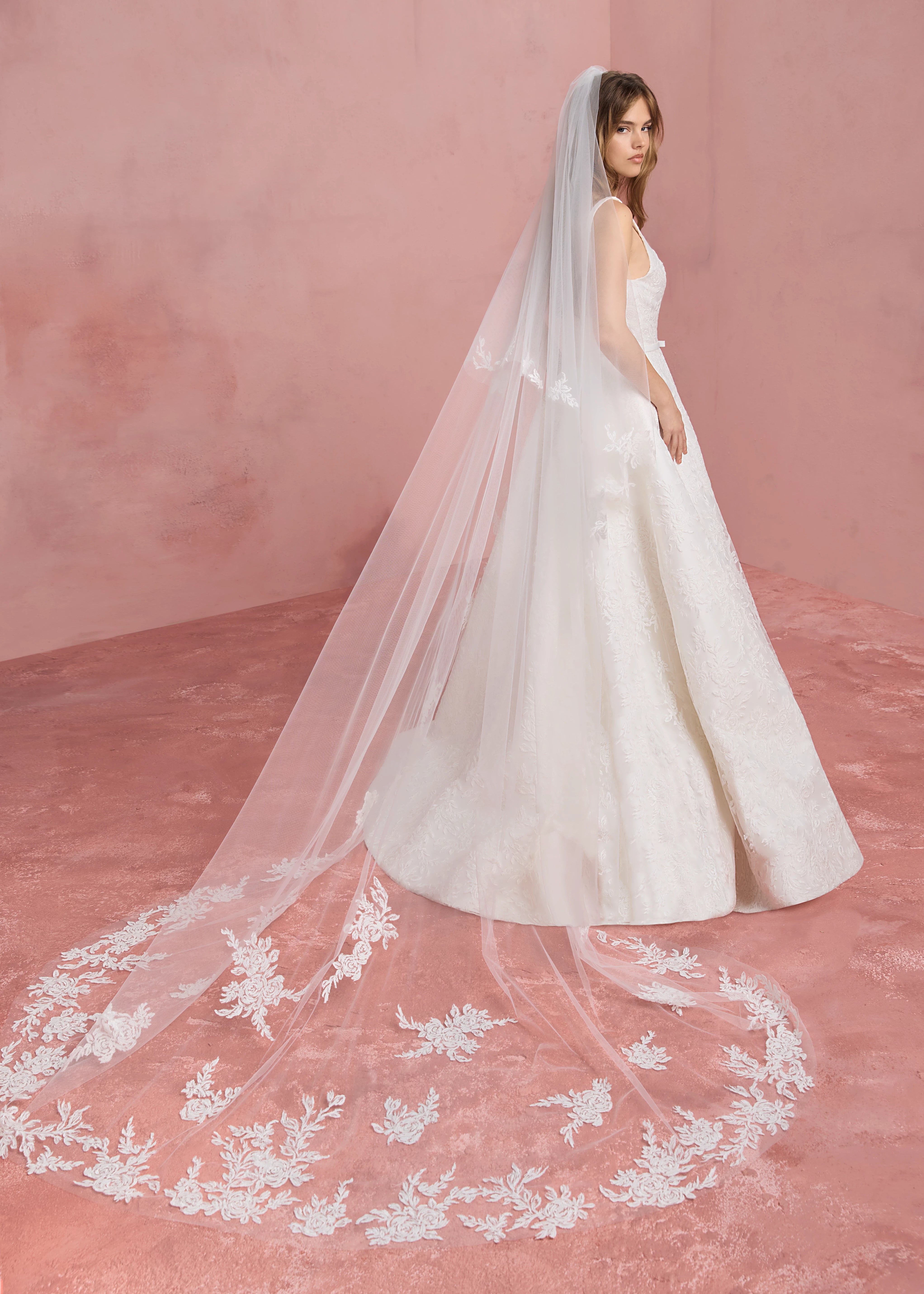 The Amelie gown paired with the The Amelie Veil is a cathedral length veil with foldover blusher, featuring Thread-Sketched Floral Embroidered Appliques around entire edge in Pearl.