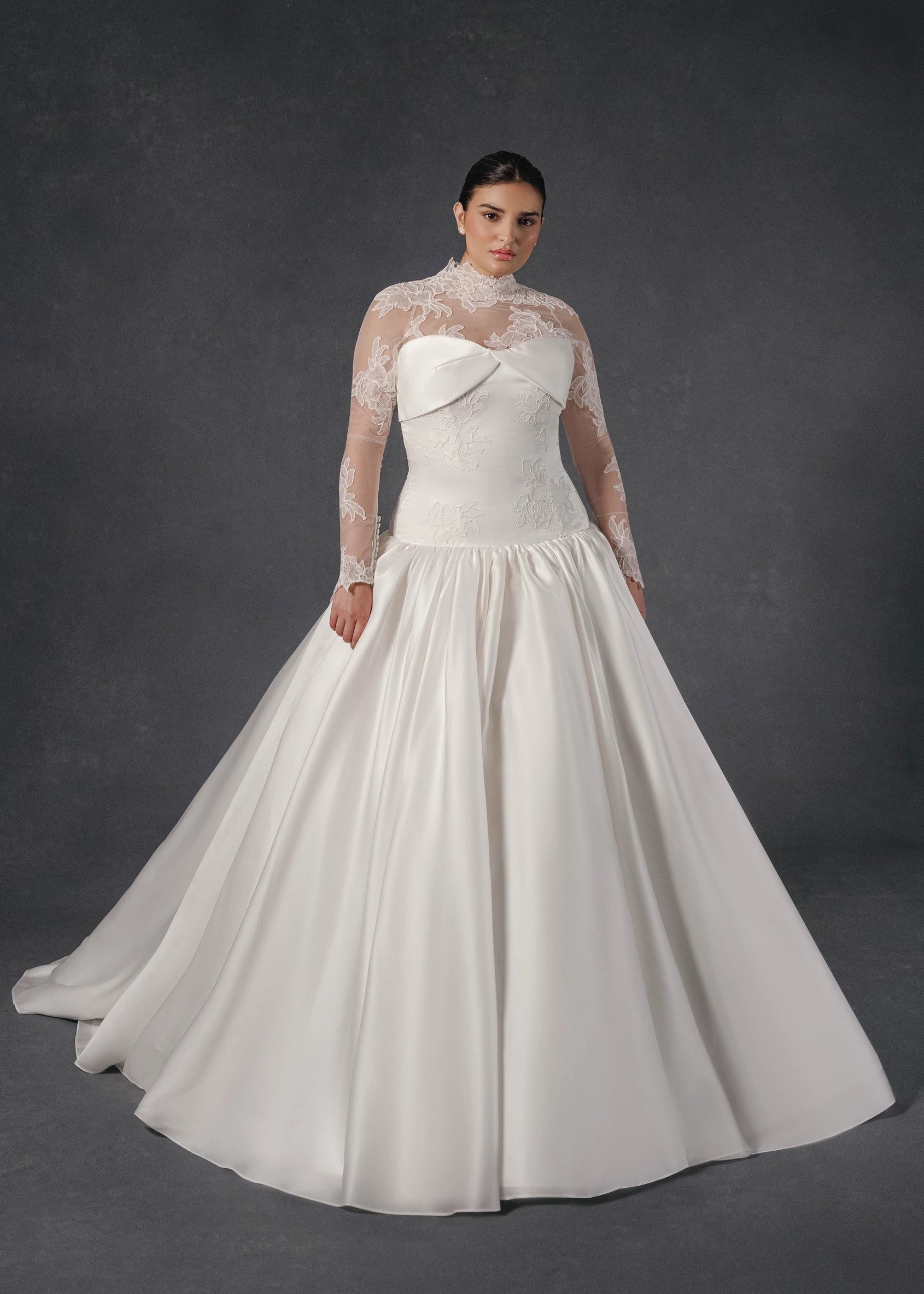 The Noblesse gown is a contour strapless drop waist ball gown of Silk Satin Organza with a draped neckline, delicate French Alençon lace appliqués, and a gathered skirt finished with buttons to the hem in Silk White.