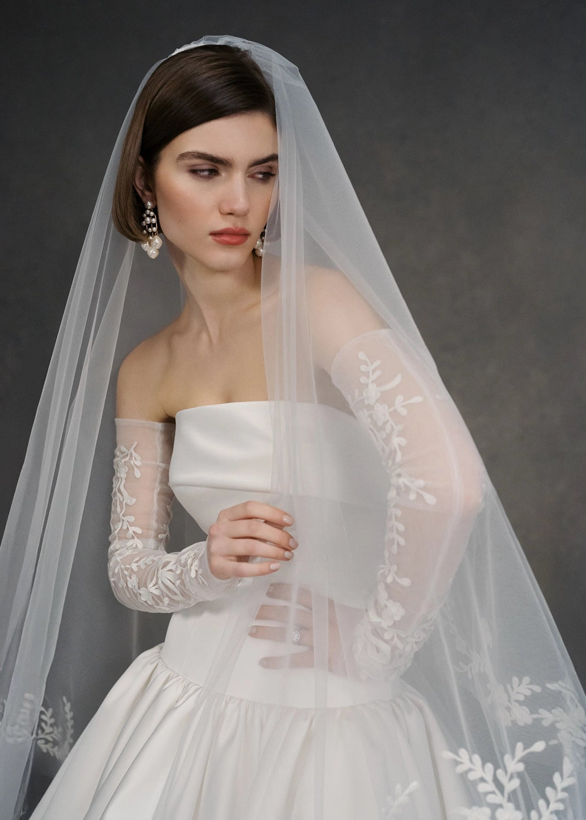The Dakota Gloves by Anne Barge are hand-embroidered Illusion tulle fingerless gloves featuring vine motifs with bows on each wrist in Silk White.