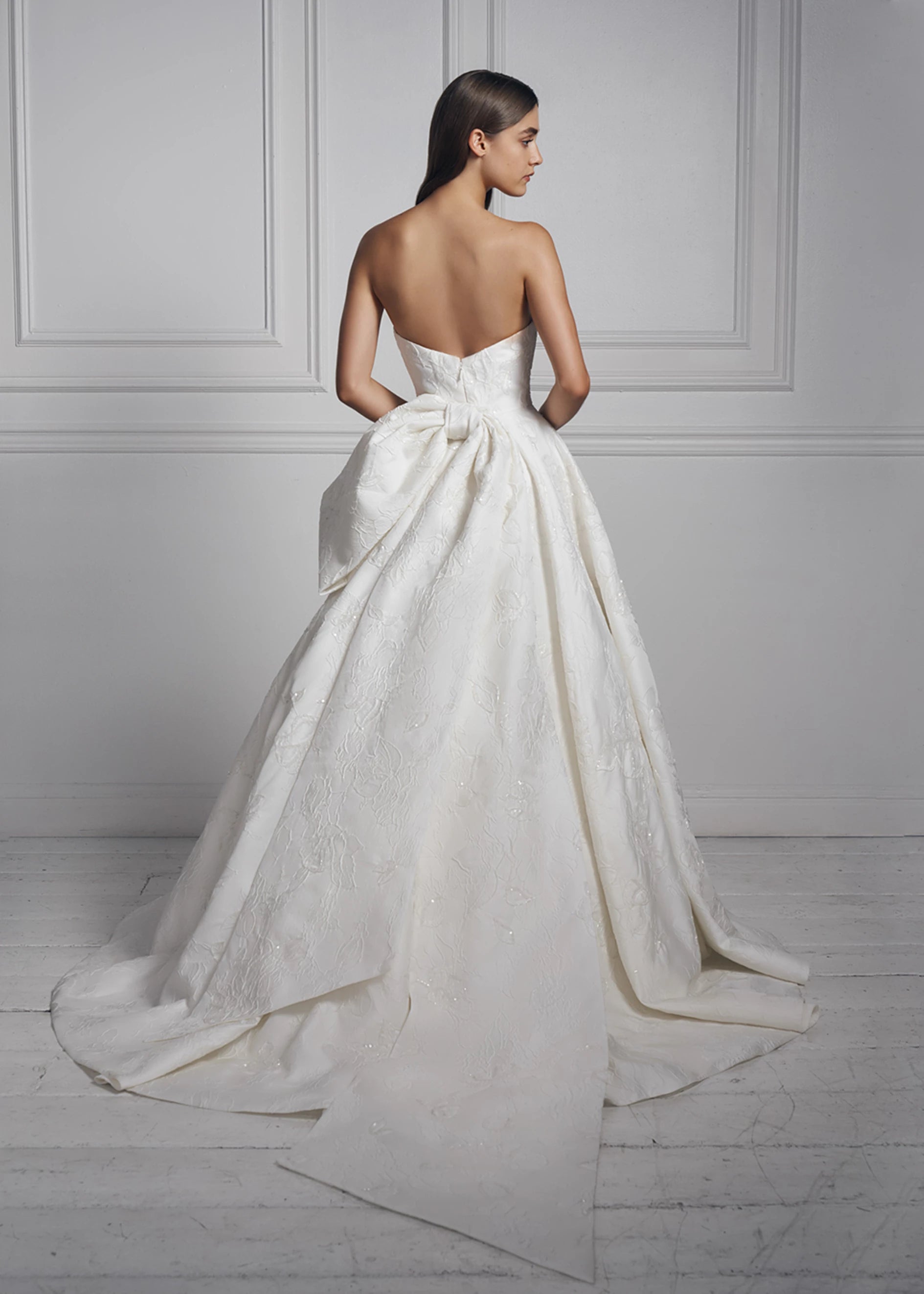 The Anne Barge Dream Weaver Bow is an asymmetric bow with extended tails of hand-beaded Floral Embossed Jacquard in Silk White.