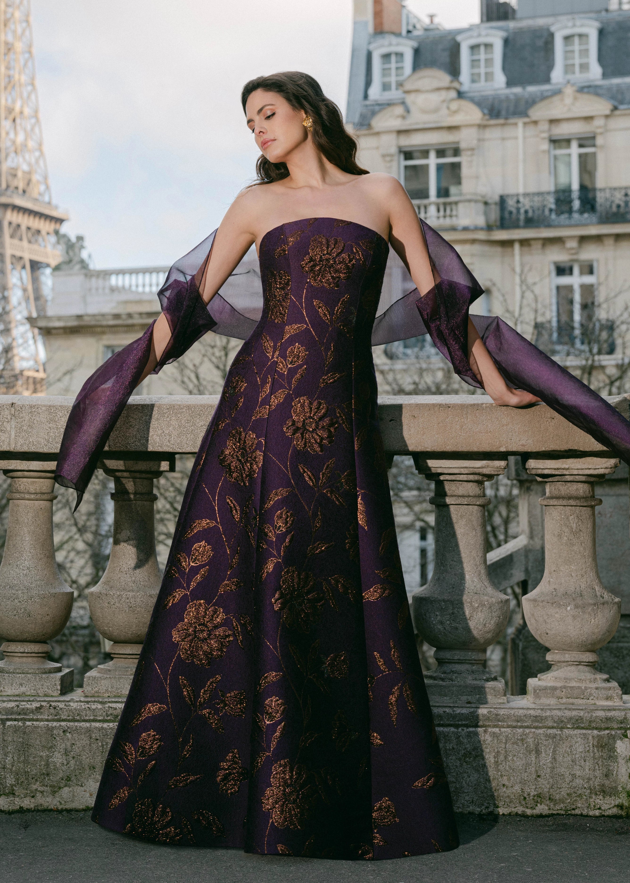 The L'Opera evening gown from Black Label by Anne Barge is an arched strapless modified A-line gown of Metallic Floral Brocade.