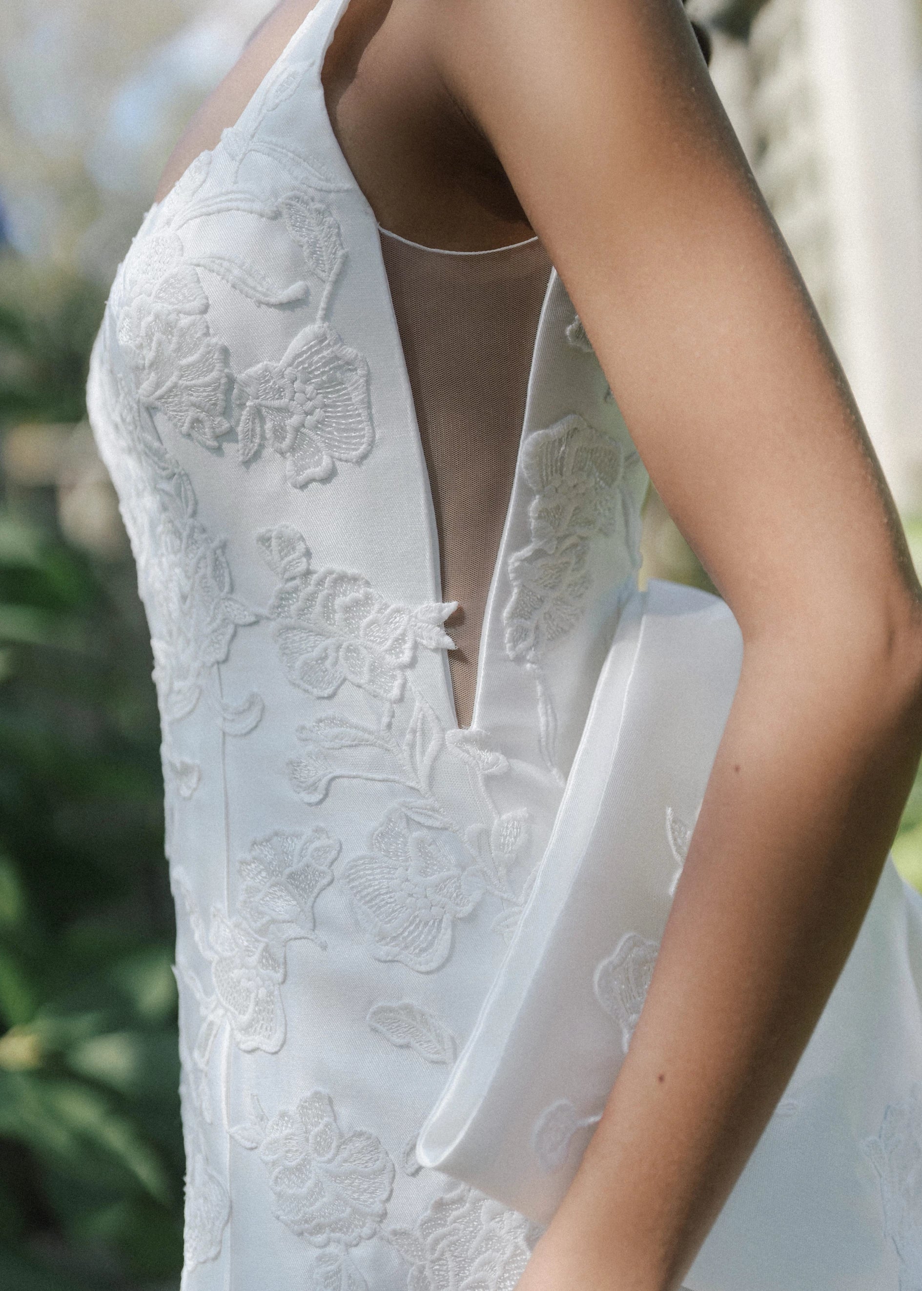 The Blue Willow Sayle Bow is an asymmetric bow of Mikado dotted with Floral Vine Embroidery appliqués in Silk White.