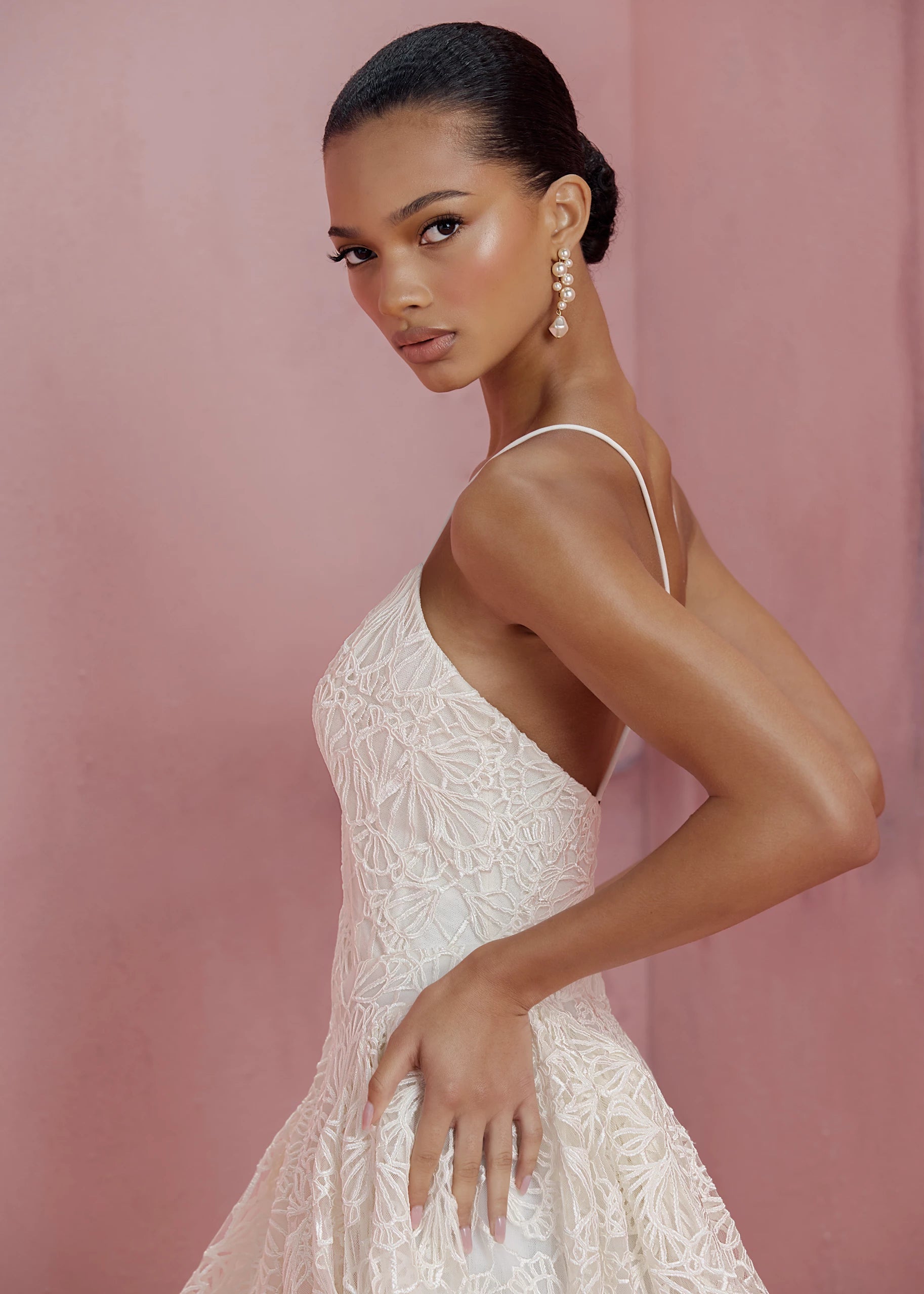 The Cecily gown is a spaghetti strap gown of Corded Satin Stitch Embroidery with basque waist, and architectural hip flares, flowing into a full A-line skirt in Pearl.