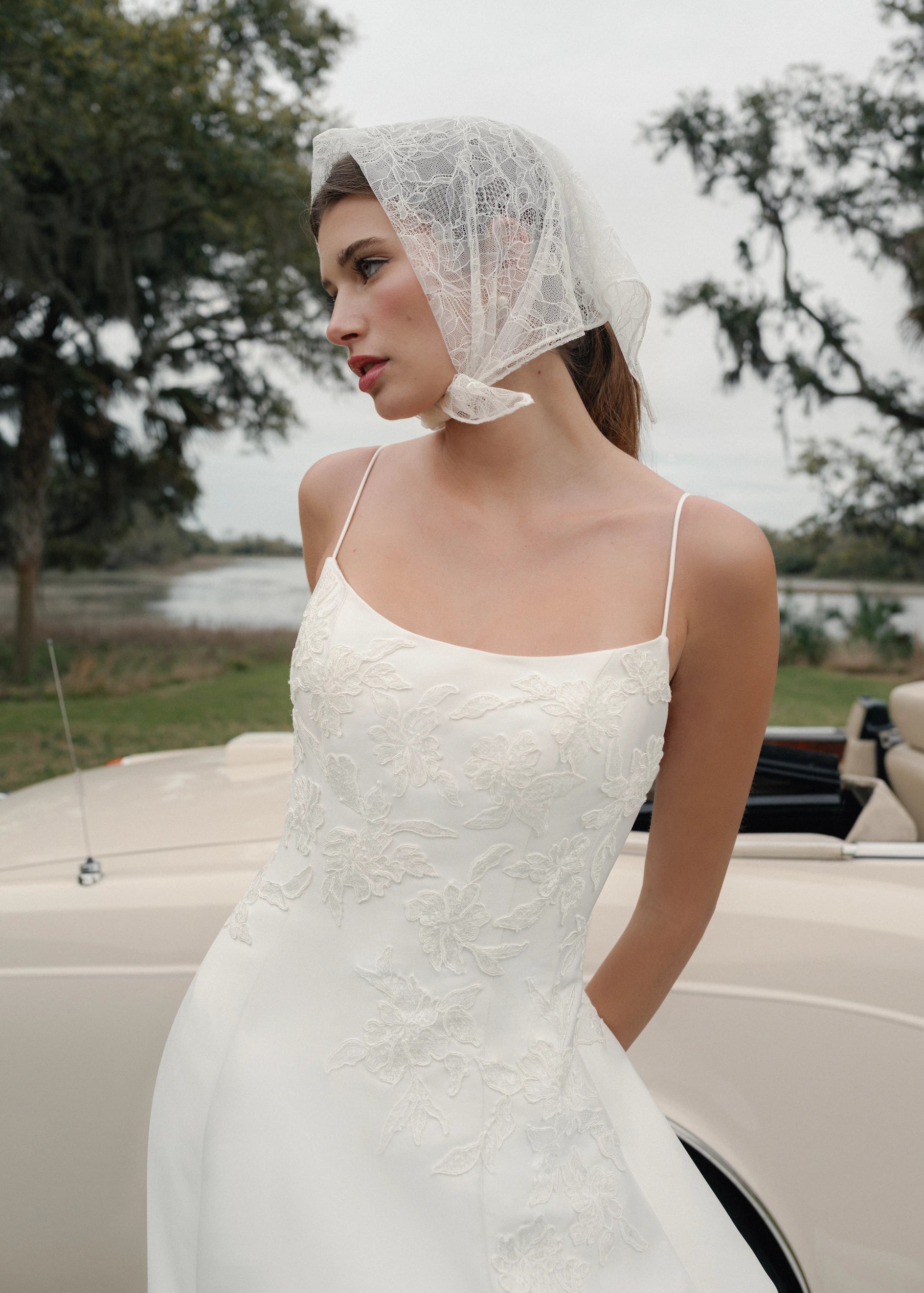 The Charlie gown is a scoopneck spaghetti strap A-line gown of Soft Mikado with Sequined Corded Floral Lattice appliqués in Pearl.