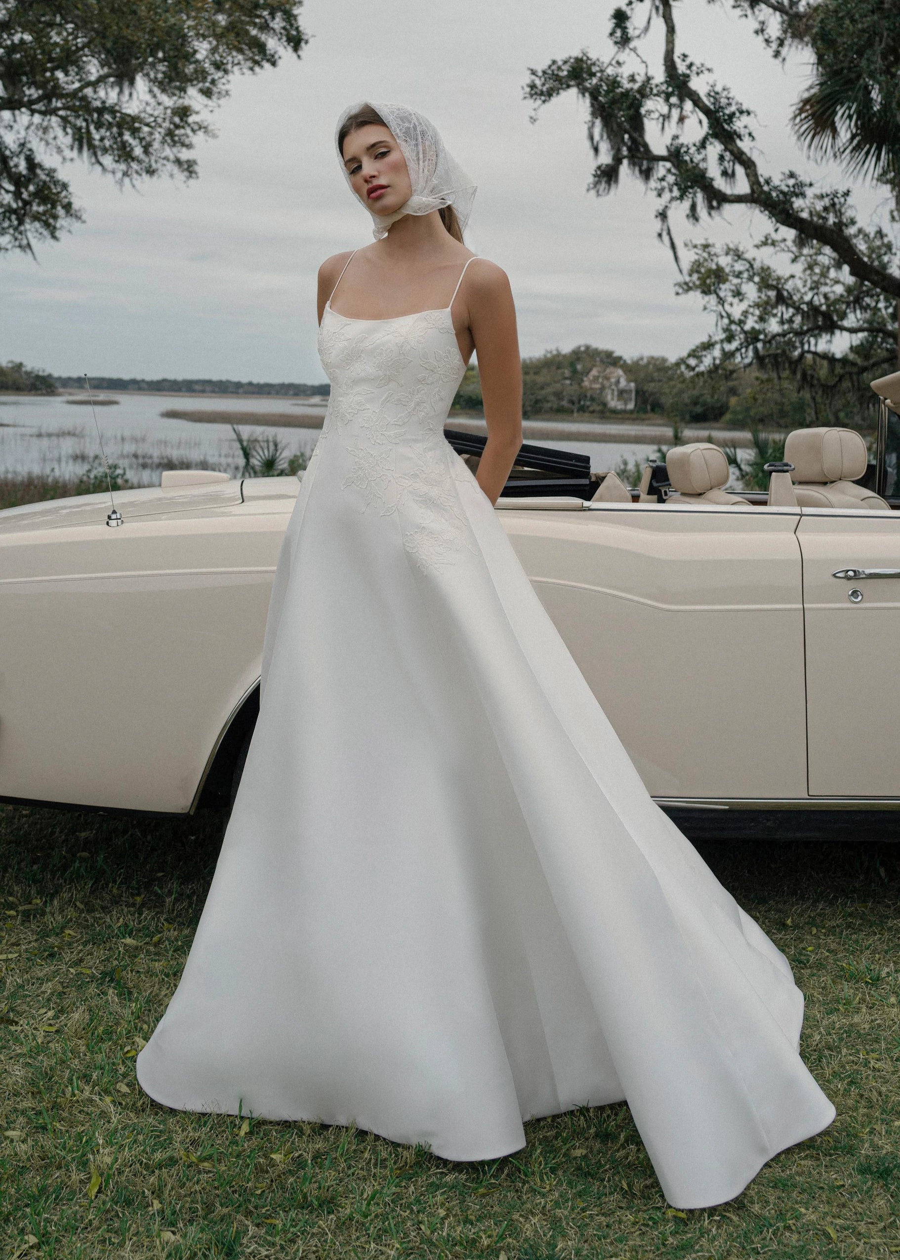 The Charlie gown is a scoopneck spaghetti strap A-line gown of Soft Mikado with Sequined Corded Floral Lattice appliqués in Pearl.