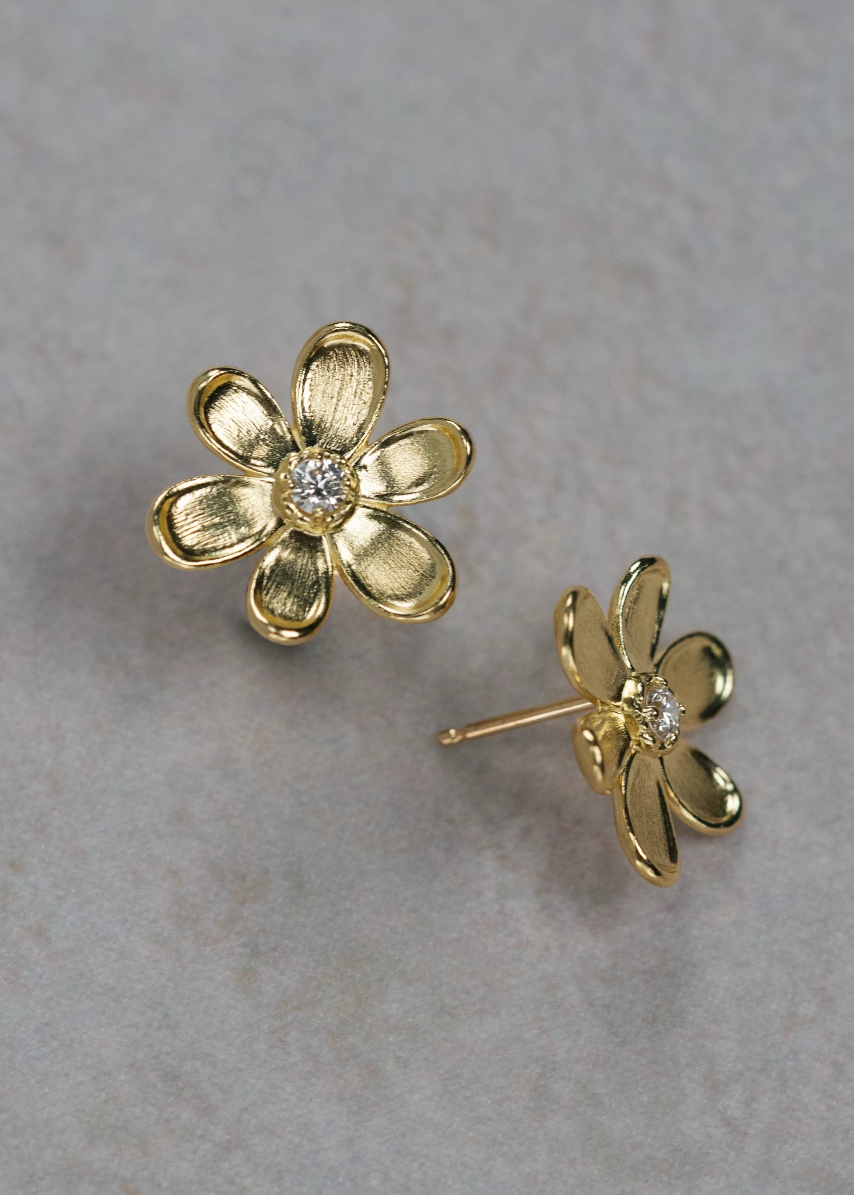 Designed by Atlanta jewelry designer Laura Pearce, delicate Daisy flower studs, featuring a 0.20 CTTW brilliant diamond, and available in 8K Yellow or White Gold.