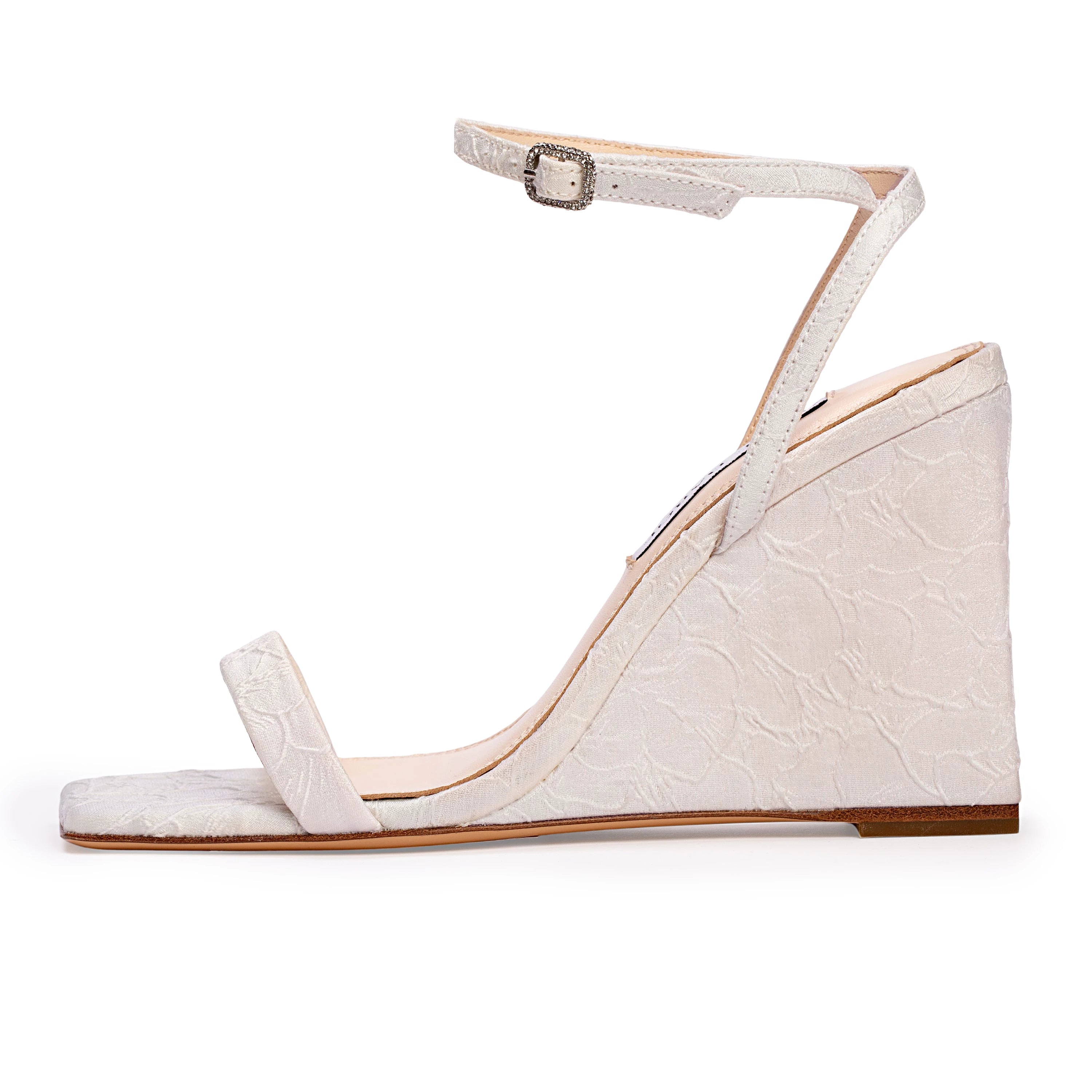 A square-toe wedge sandal set on a classic 95mm heel, featuring a sleek, minimalist upper accented by a square crystal-embellished buckle. Expertly crafted from refined satin jacquard.