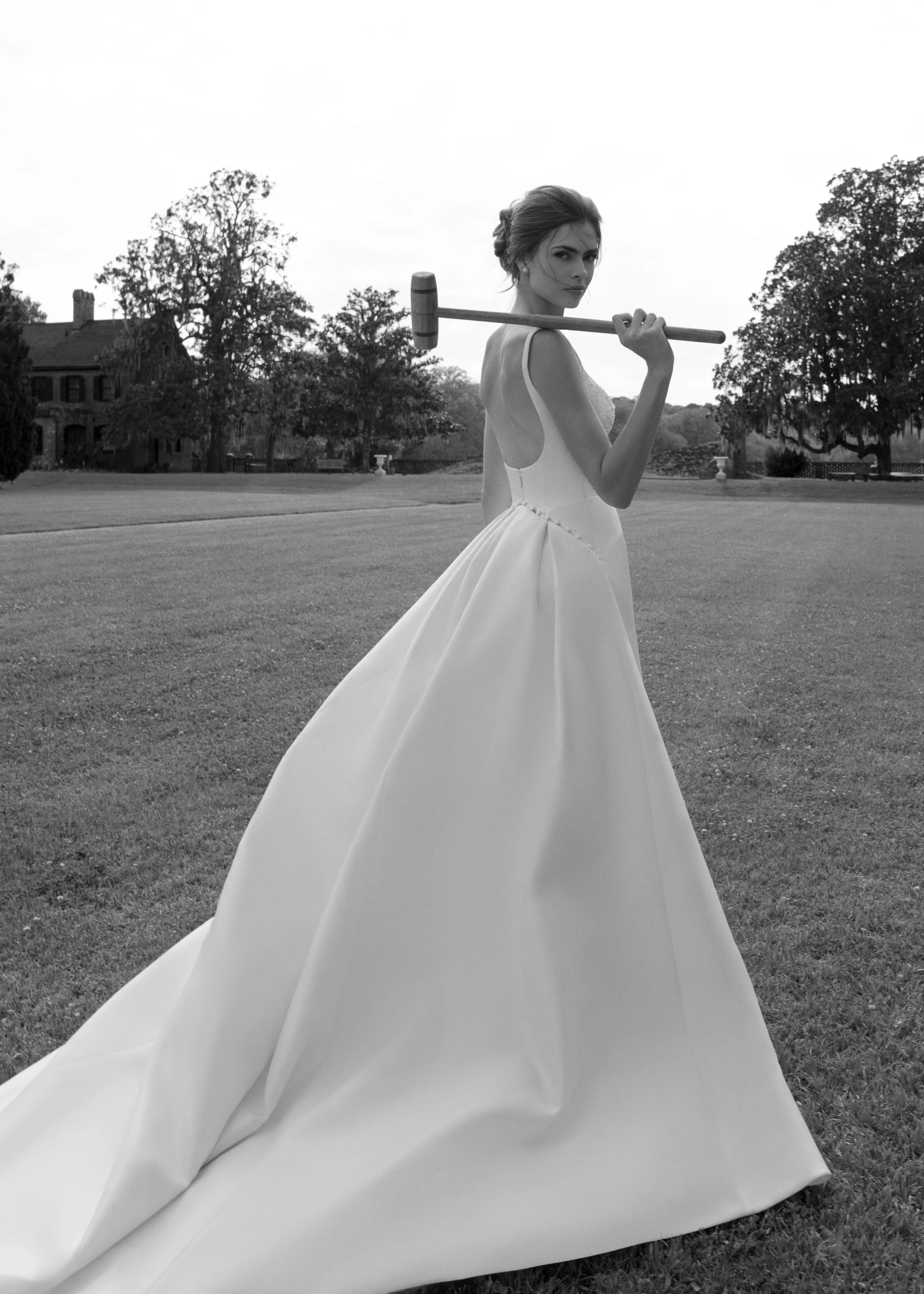 The Henrietta gown is a soft scoop neck trumpet gown of Italian Kalika with architectural seaming, featuring French Alençon lace framing the neckline.