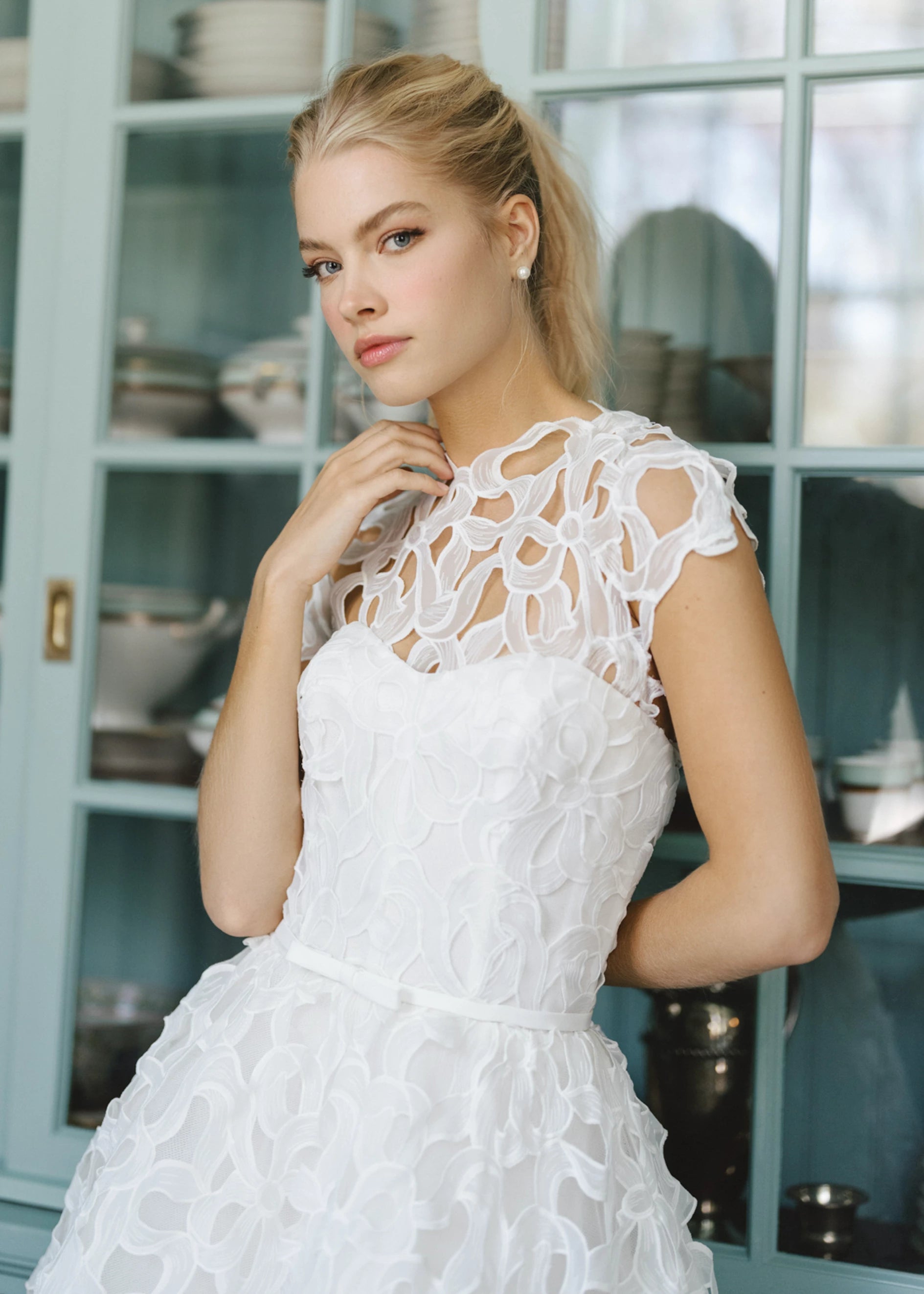 The Blue Willow High Meadows Topper , a Sleeveless top of bow shaped laser cut organza with embroidered edges in Silk White.