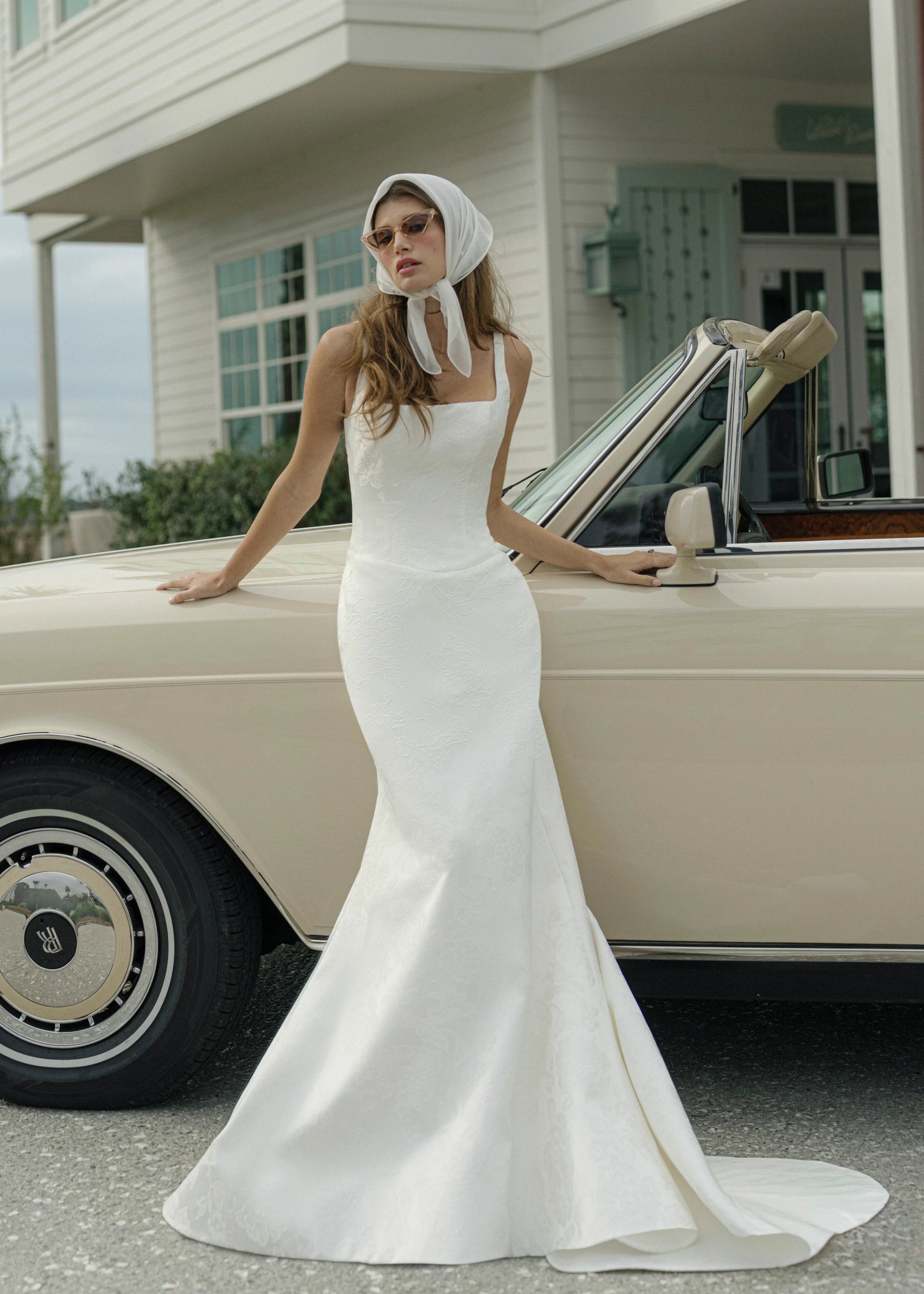 The Kiawah gown is a square neckline fit and flare gown of Embossed Jacquard with curved drop waist in Pearl. 