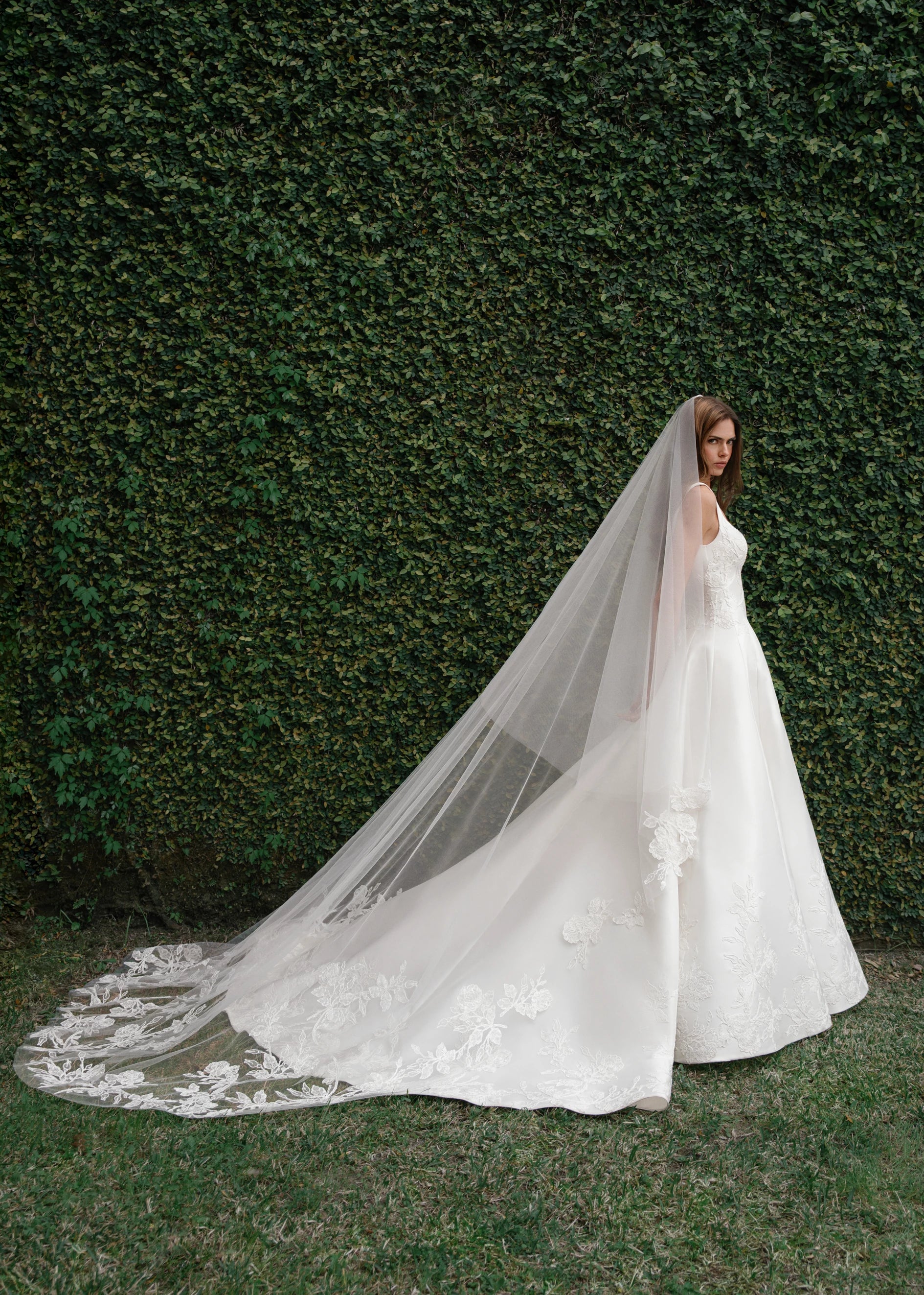 The King gown is a softly contoured sweetheart neckline A-line gown of Italian Kalika with Floral Vine Embroidered Lace appliqués framing the bodice and all around the skirt hem in Silk White.