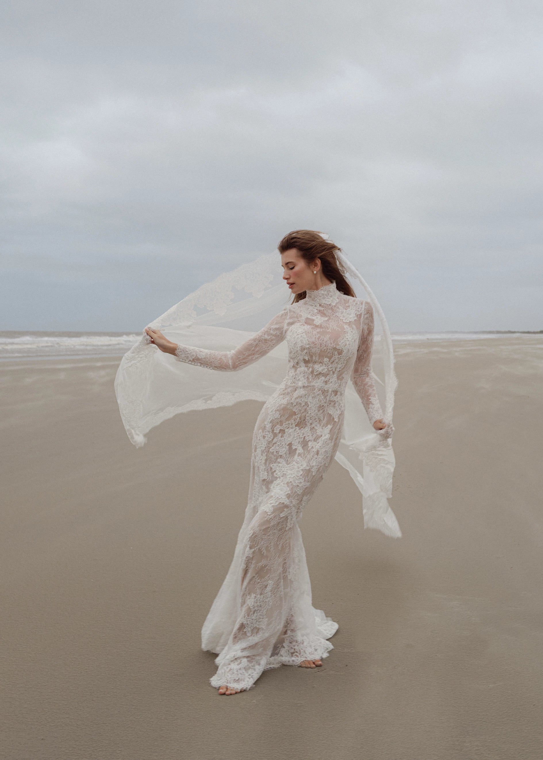 The Leo gown is a mockneck long sleeve columnar gown of Corded Lace gown with Chantilly lace underlay.
