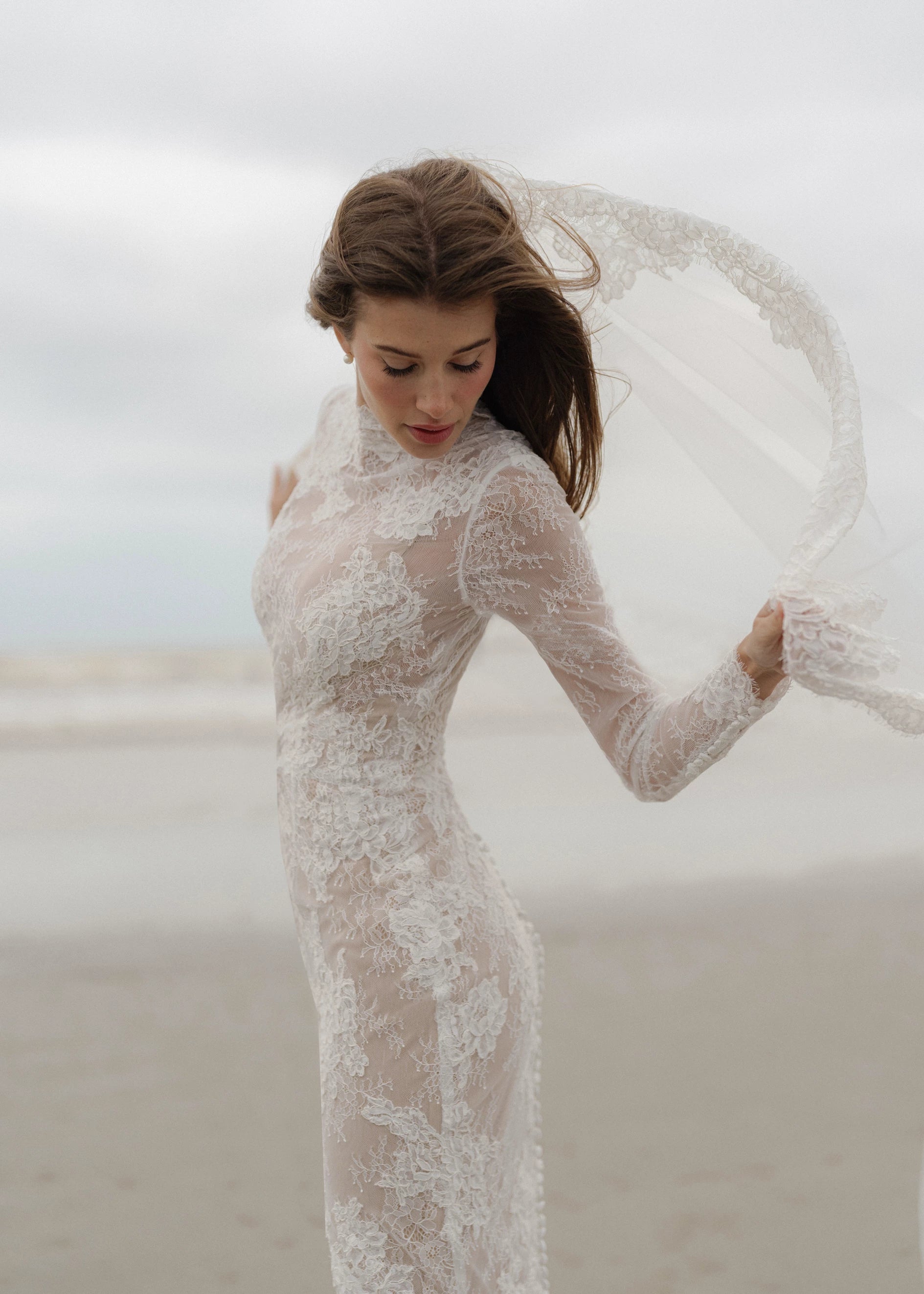 The Leo gown is a mockneck long sleeve columnar gown of Corded Lace gown with Chantilly lace underlay.