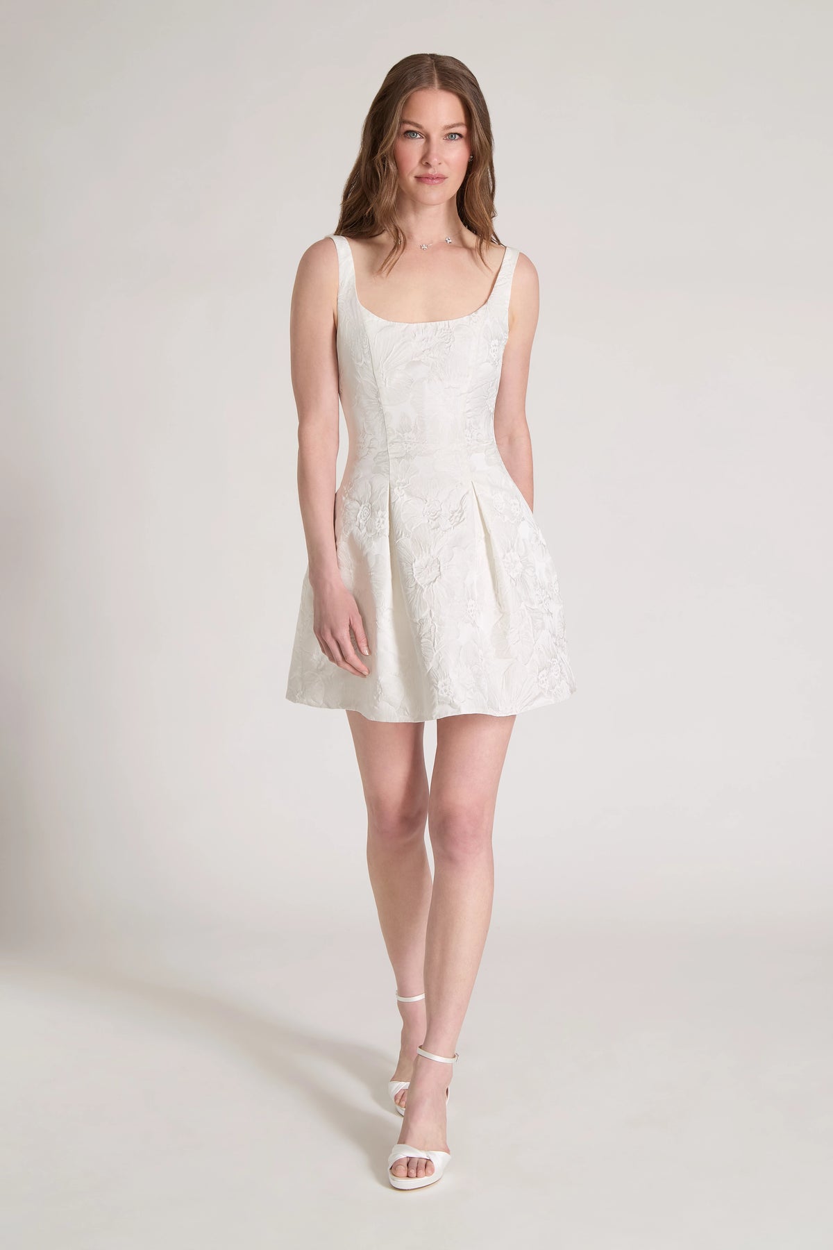 The Petal Pop Little White Dress is a scoop neck mini dress of Hibiscus Jacquard with figure flattering princess seams opening to soft pleats in Silk White.
