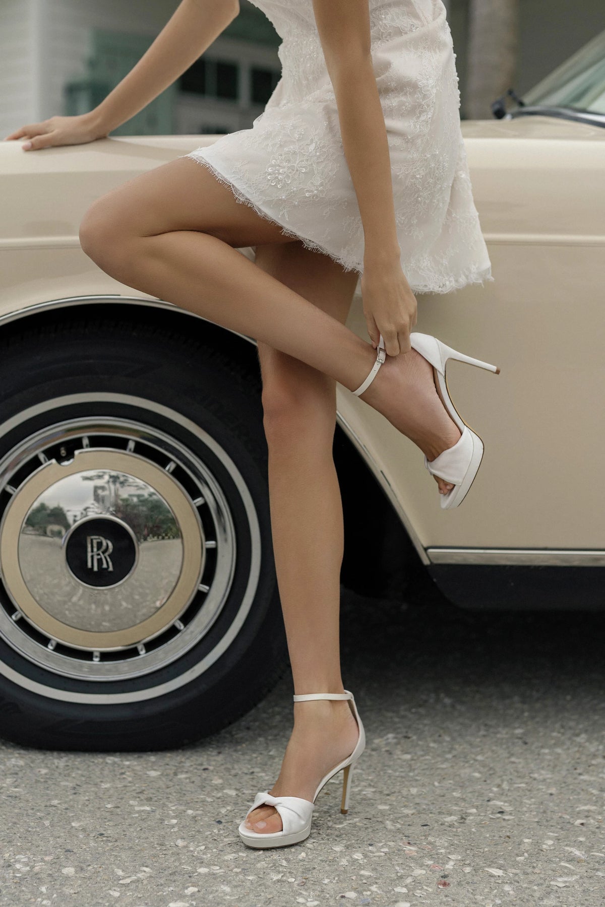 The Anne Barge Amour wedding shoe, is a round toe micro platform sandal in White Satin with a twisted upper pleat detailing, set on a 100 mm micro platform and stiletto heel.