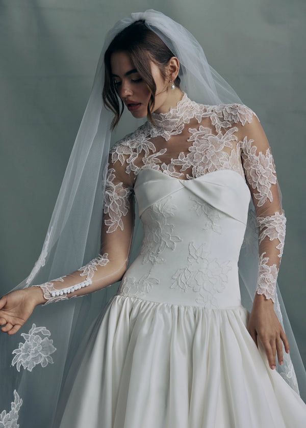 The Noblesse gown paired with the The Anouk veil, a mantilla veil with Corded Scrolling Floral Lace border in Silk White. 