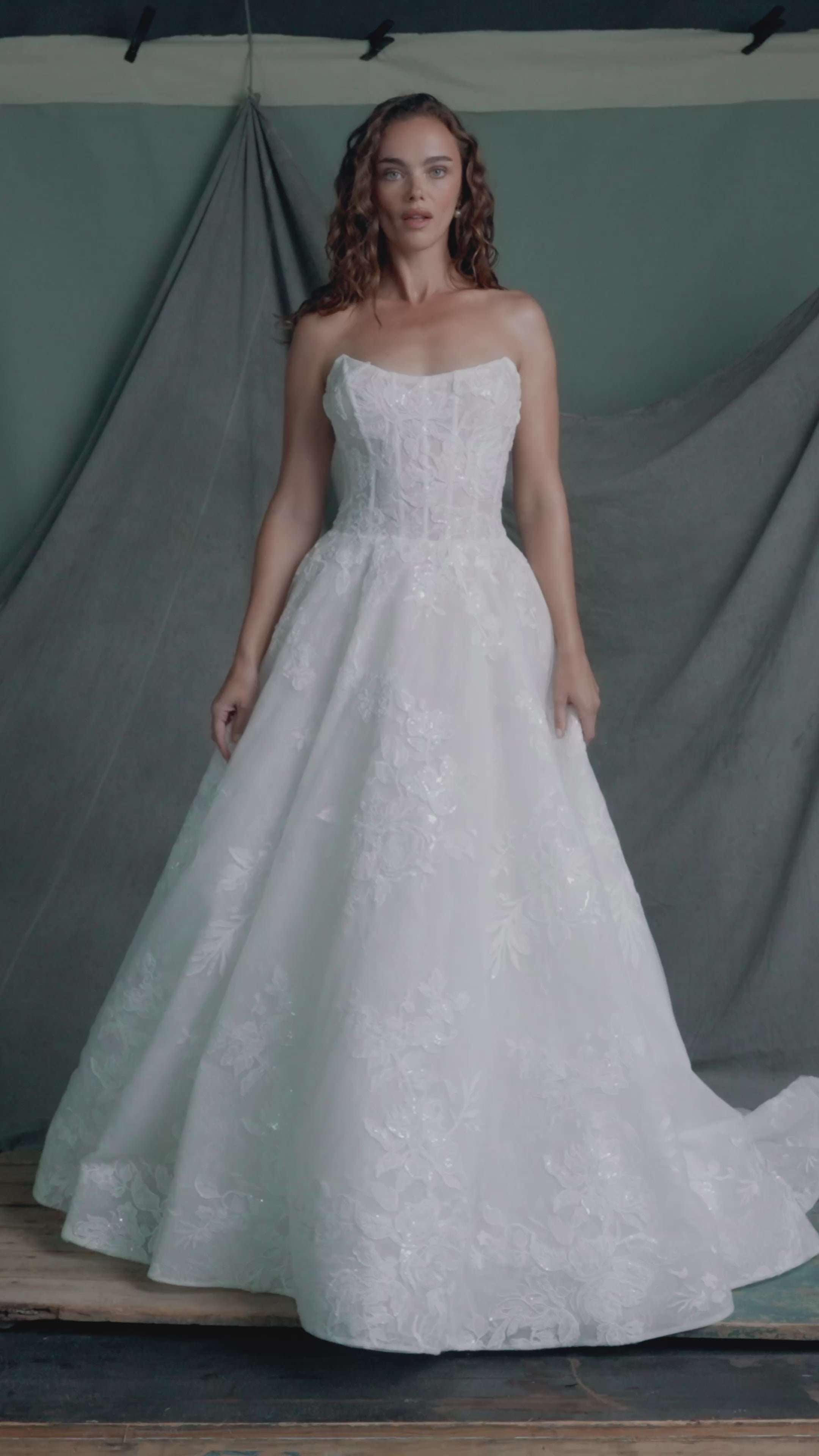 The Regalia gown by Anne Barge is a scoopneck strapless tulle ballgown, with slightly dropped waist, adorned with trickling Beaded Embroidered Appliques over Chantilly lace.