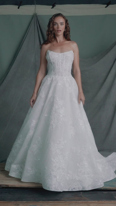 The Regalia gown by Anne Barge is a scoopneck strapless tulle ballgown, with slightly dropped waist, adorned with trickling Beaded Embroidered Appliques over Chantilly lace.