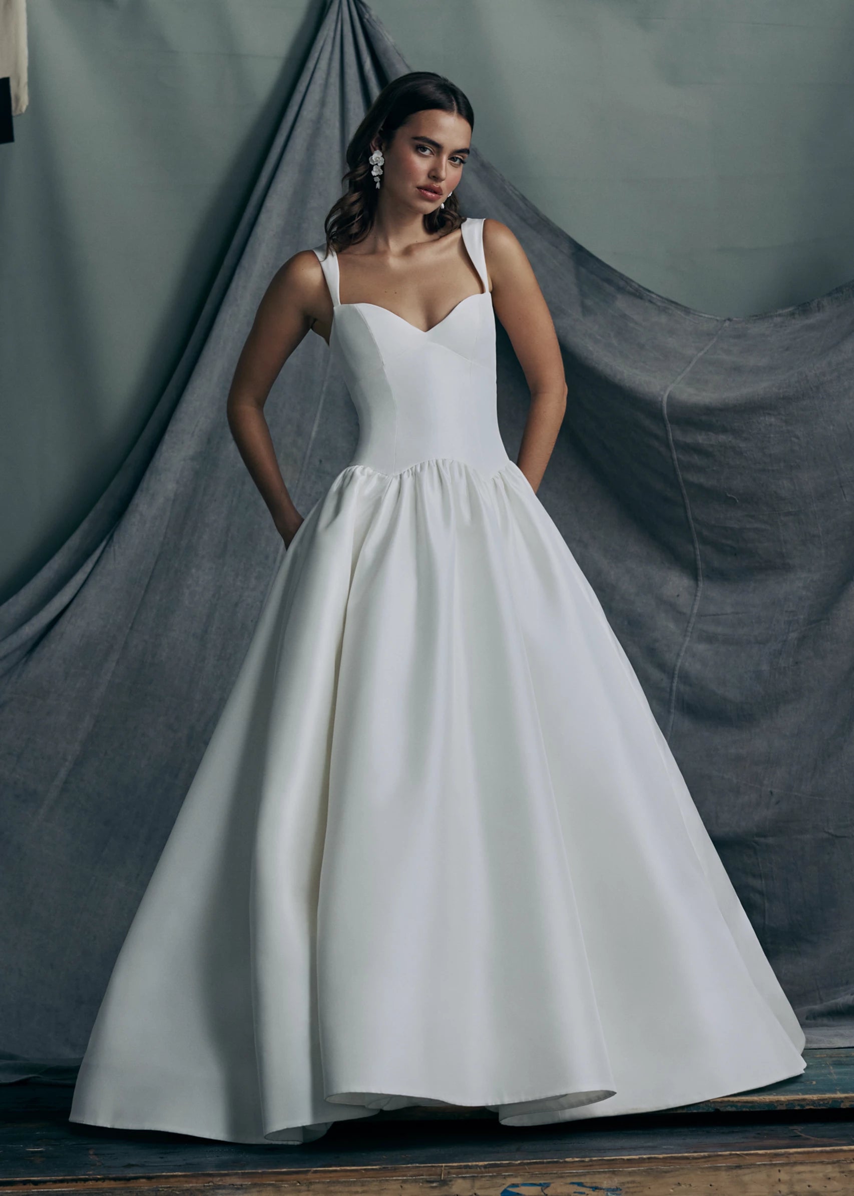 The Verite gown by Anne Barge is a sculpted sweetheart ballgown in Kalika with contour straps, featuring a ziggurat dropped waist and buttons to the hem. 